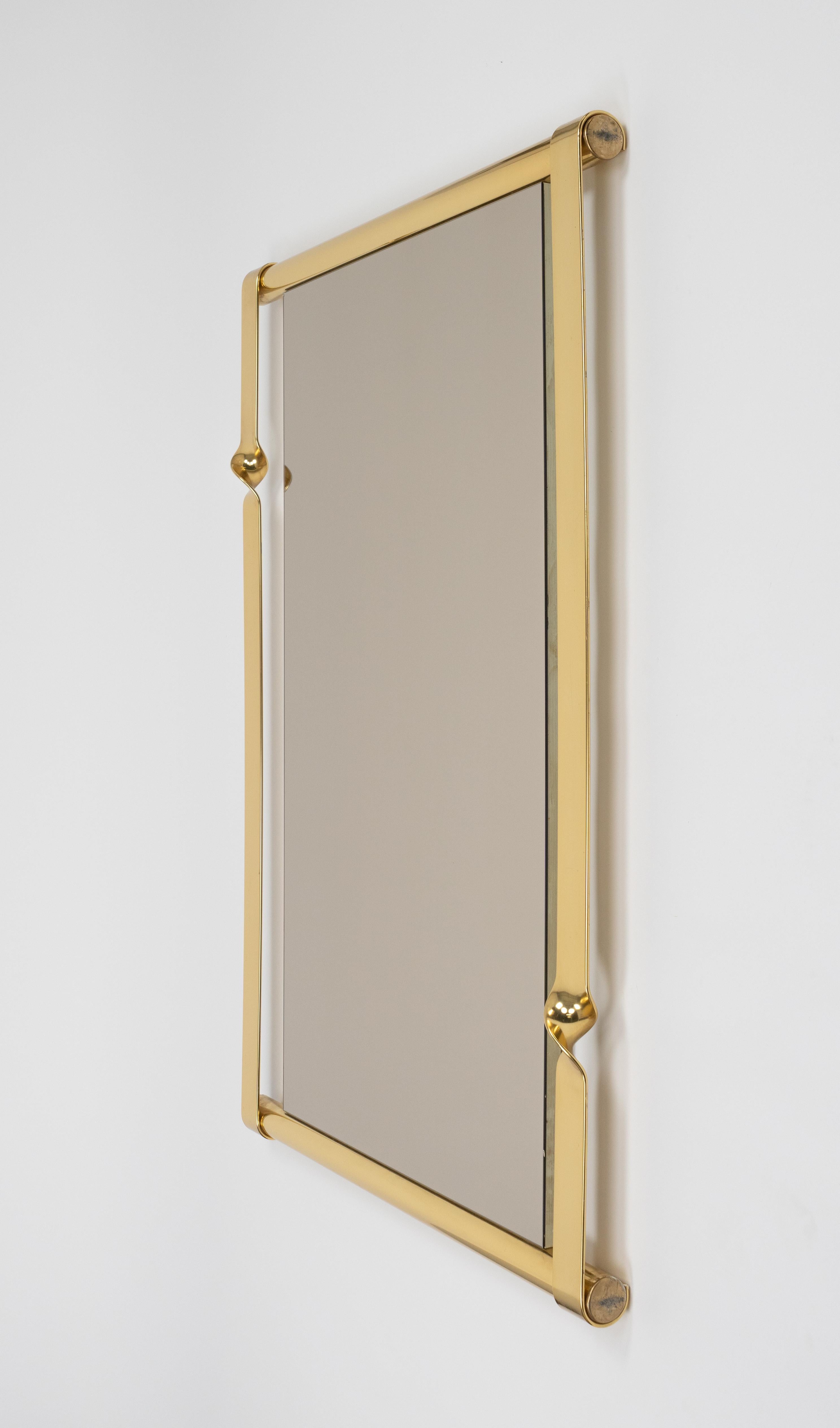 Midecentury amazing rectangular large wall mirror in brass and slightly bronze tinted mirror by Luciano Frigerio.

Made in Italy in the 1970s.

The rectangular shape of the mirror with a twisted metal frame classic and timeless look that complements