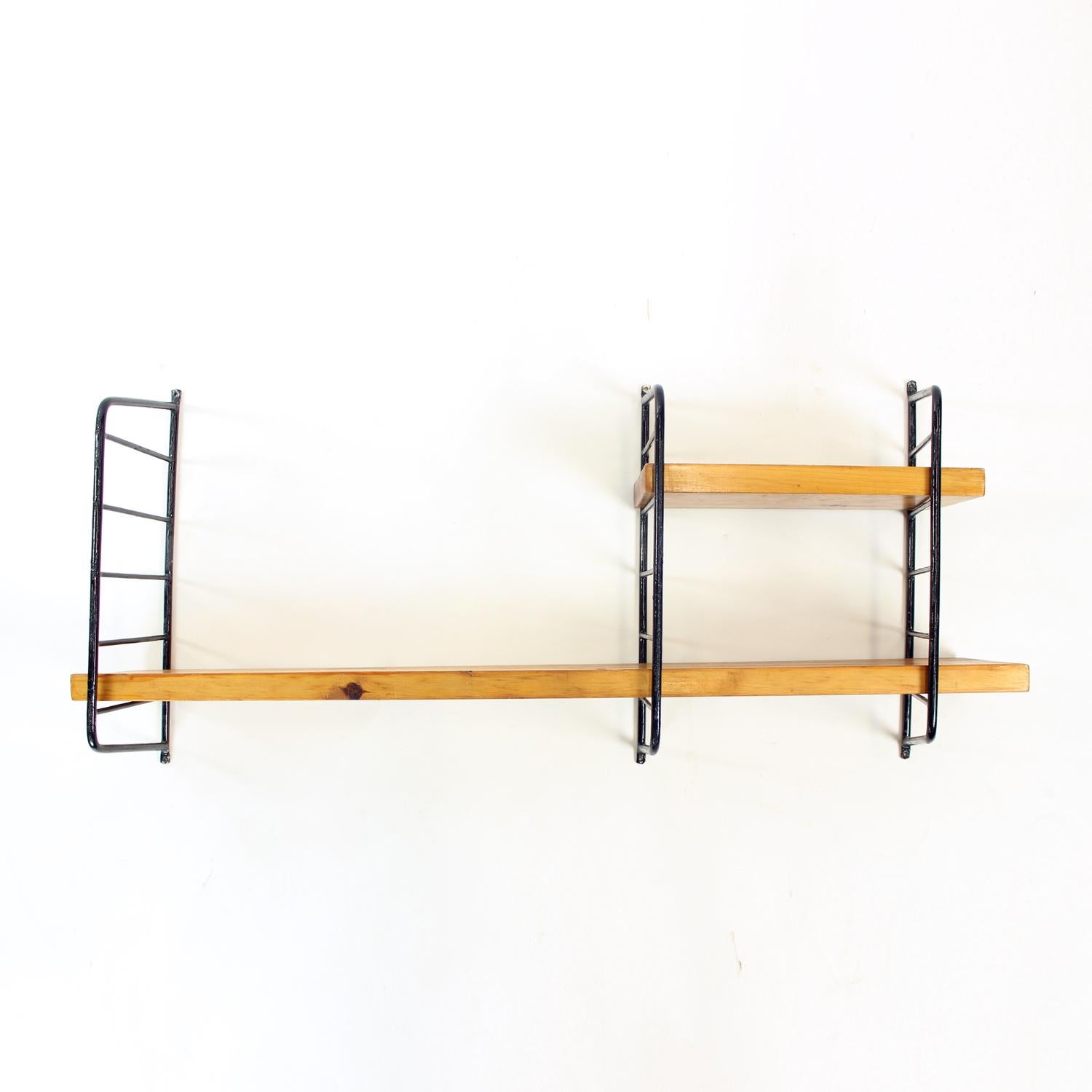 Beatiful and original midcentury shelf system. It consists of three wall mounted black metal brackets that hold two pine wood shelfs. The longer shelf is 1 meter long, the smaller one is 35cm long. The wooden boards are original, and wide enough to