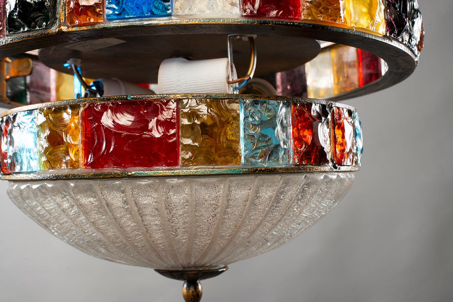 Light fixture found in Italy features a bronze colored iron frame with hand blown thick clear, bubbly glass globe and two bands of multicolored glass squares, circa 1960. Three regular sized internal sockets have been updated for US electrical