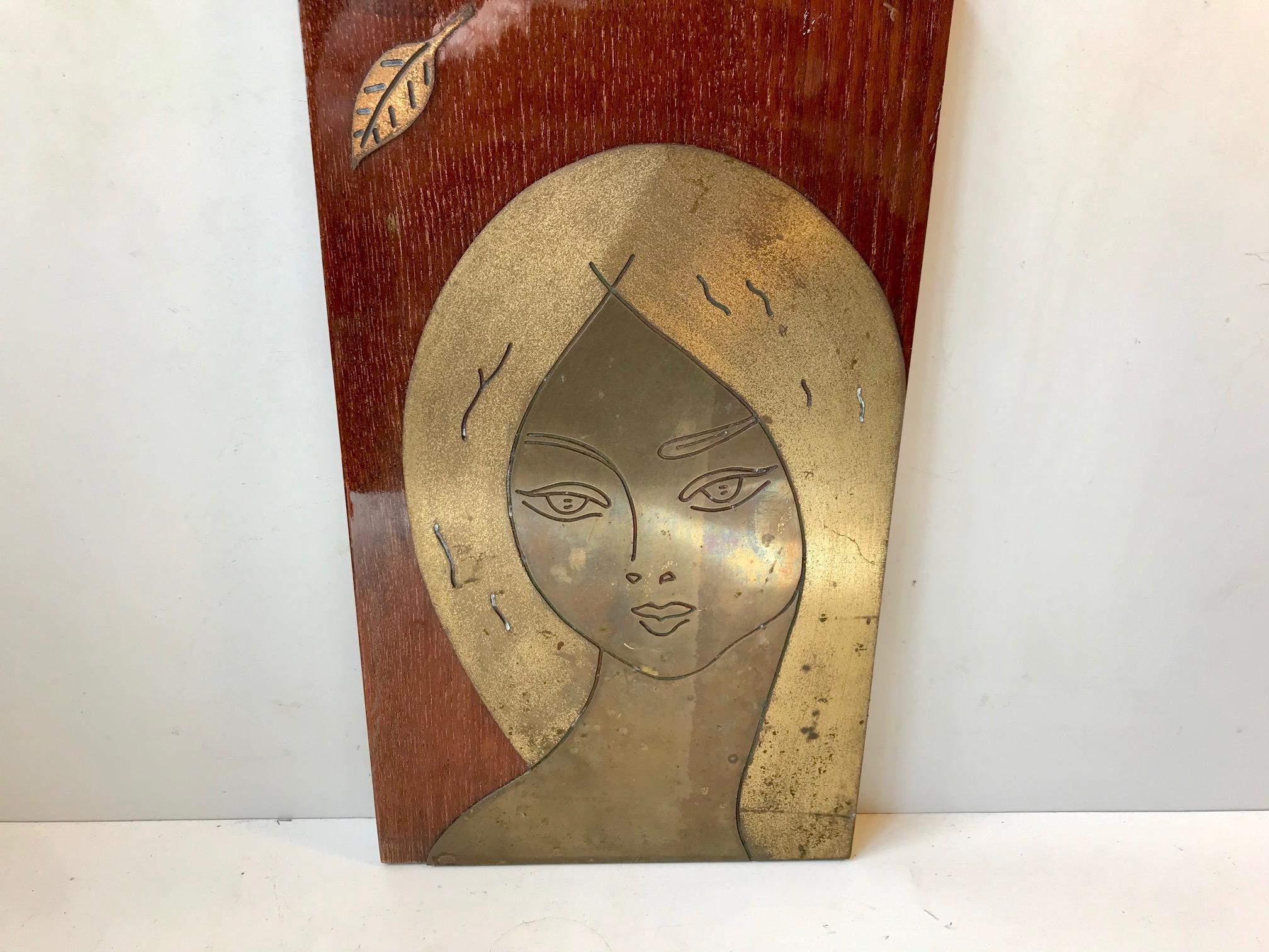 This may be a take on Postmodern iconography. Saint Philomena anno 1960? Nevertheless this unique hand crafted brass wall plaque incapsulates the characteristics of the 1950s and 1960s pin-up culture while maintaining a certain purity. The old fated