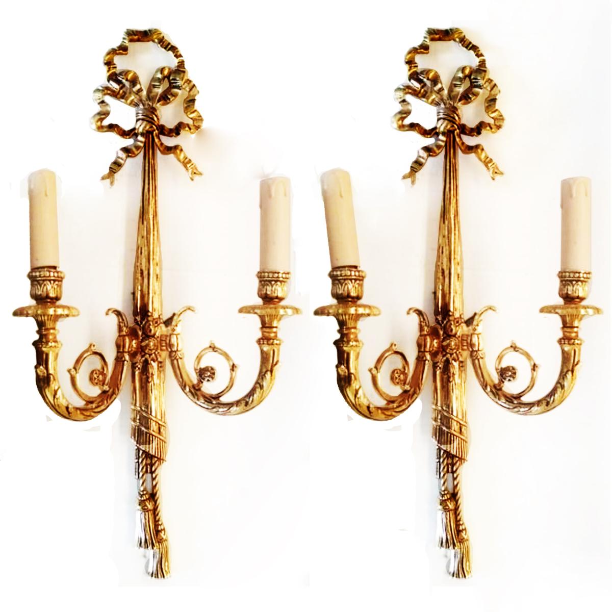 Midcentury Louis XVI style gilt bronze or brass two-light wall sconces

This elegant two-light Louis XVI style wall sconce. At the top there is a tassel, a typical element of Louis XVI period

They are in very good condition.
 
*For any questions