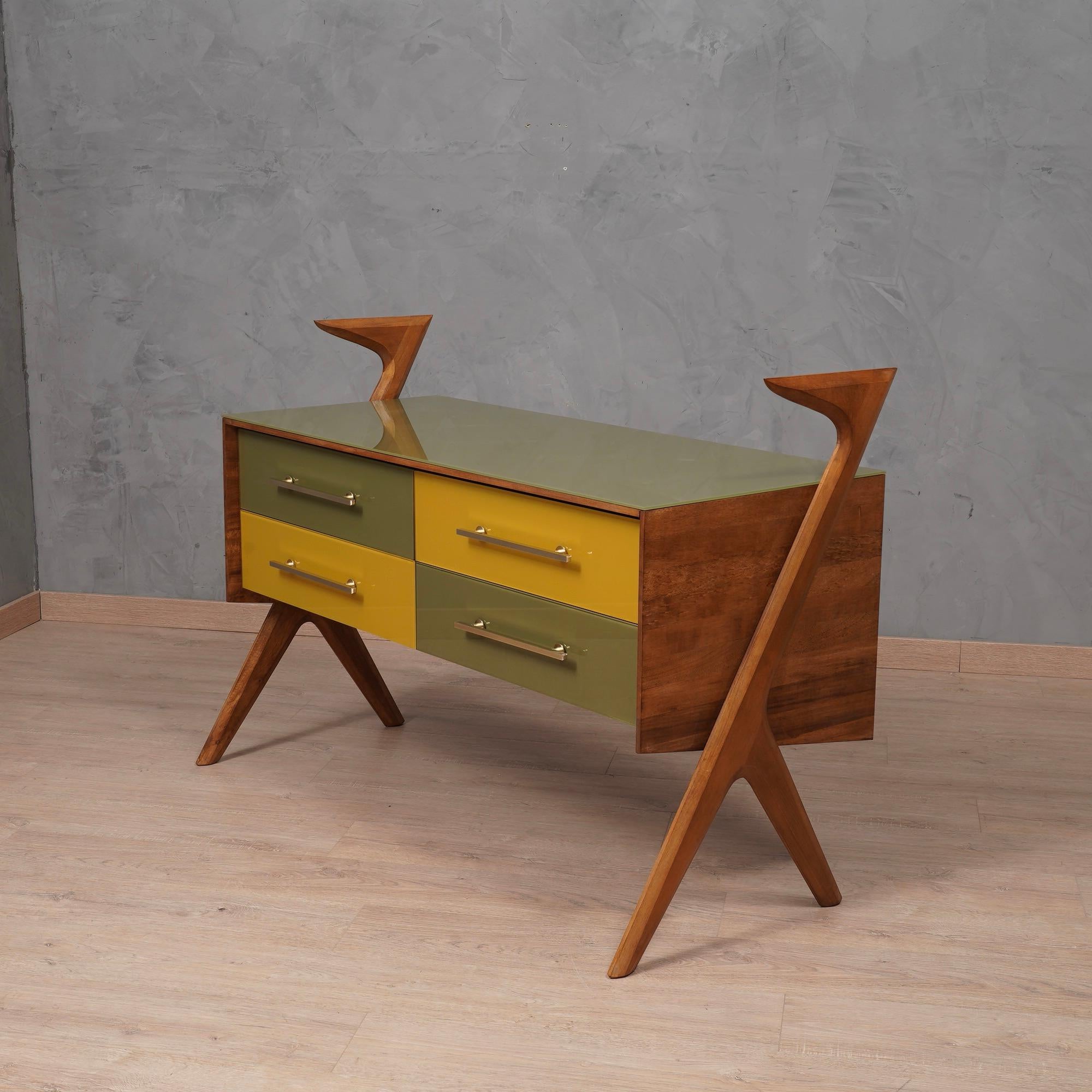 Very special design for this all-Italian chest of drawers in walnut wood and yellow and dove gray lacquered glass. Matching colors with a very fine taste.

The chest of drawers is formed by a central body which contains four drawers, stacked two by