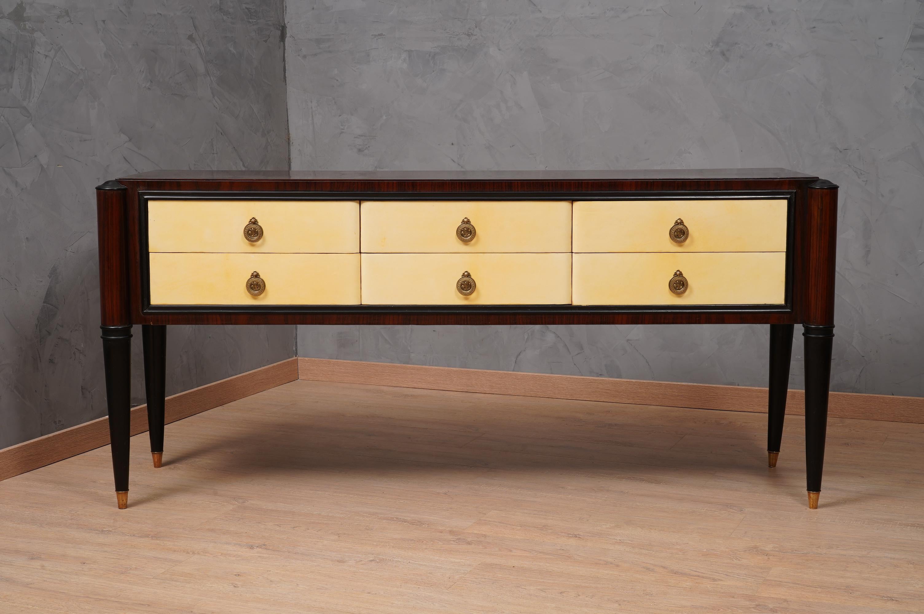 Italian Art Deco dresser of the first half of the last century. One can recognize his Italian style, Paolo Buffa, Vittorio Dassi, Osvaldo Borsani. Precious materials that have been used to compose it, from parchment leather to walnut to brass. Its