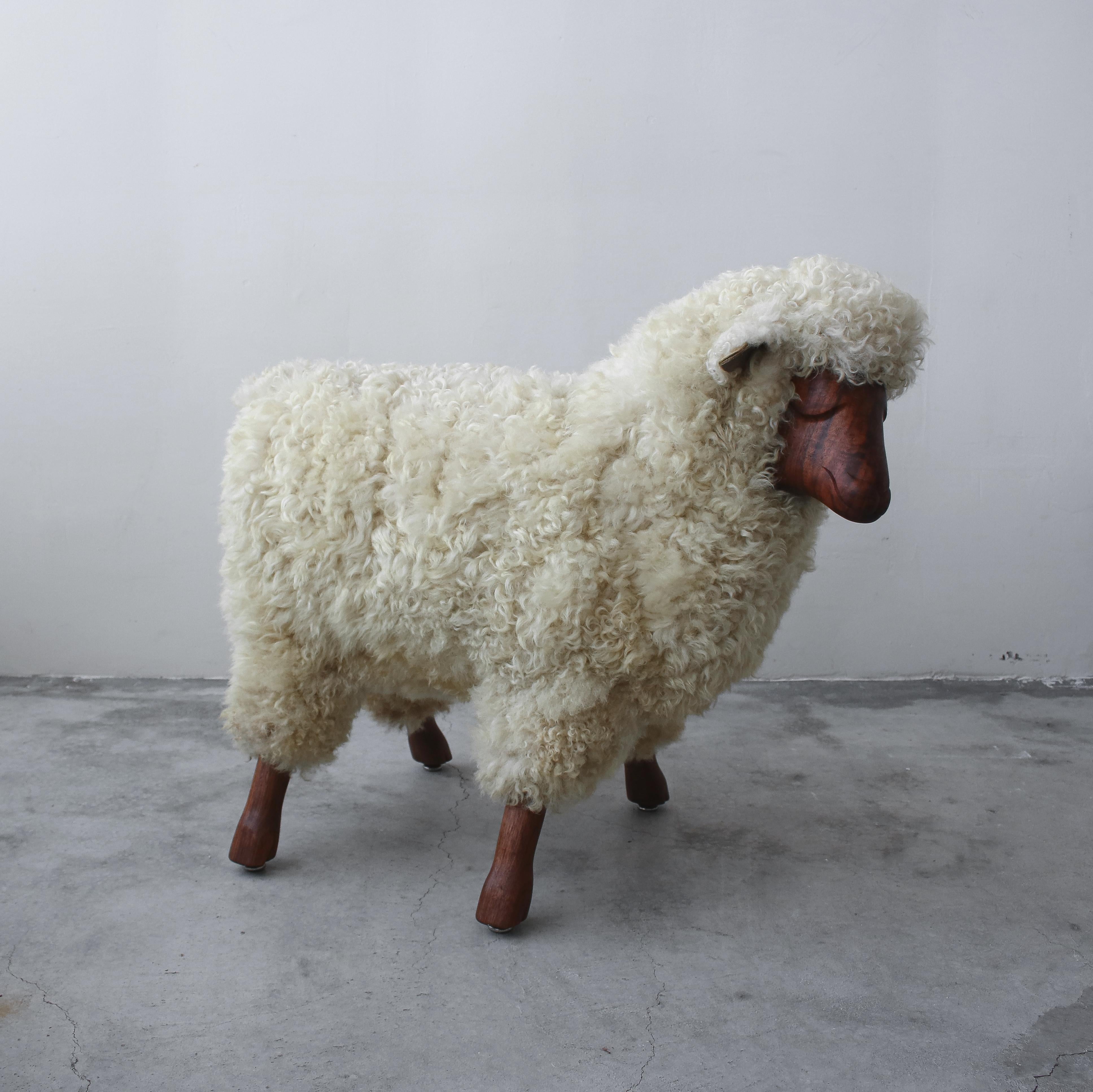 A beautiful midcentury sheep sculpture. These sheep sculptures are beloved for their whimsical wooly appearance.

This sheep is a beautiful piece, constructed of authentic wool and carved walnut face and hooves. Wool is slightly yellowed from age.