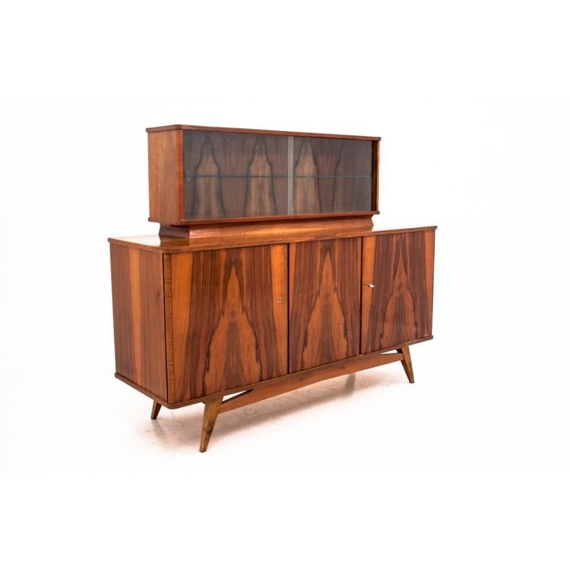 Retro commode comes from Poland. It was produced in the early 1970s. for Lódzkie Fabryki Mebli. Walnut veneer with creates decorative patterns on its surface