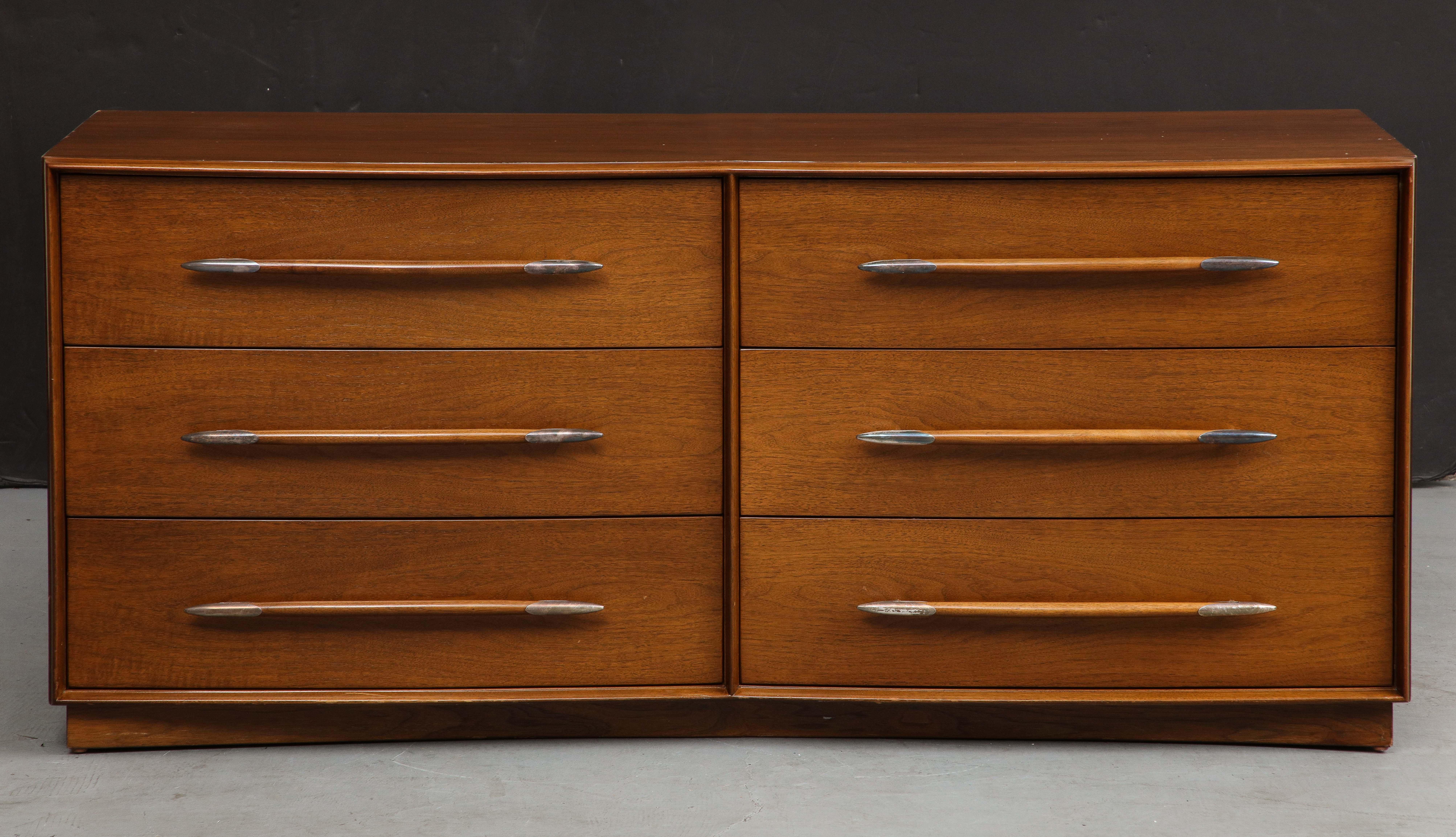 Midcentury walnut dresser, featuring six deep drawers and spear-shaped carved walnut pulls with nickel-tipped ends. 

Designed by T.H. Robsjohn-Gibbings for The Widdicomb Furniture Company, 1950s. 

30