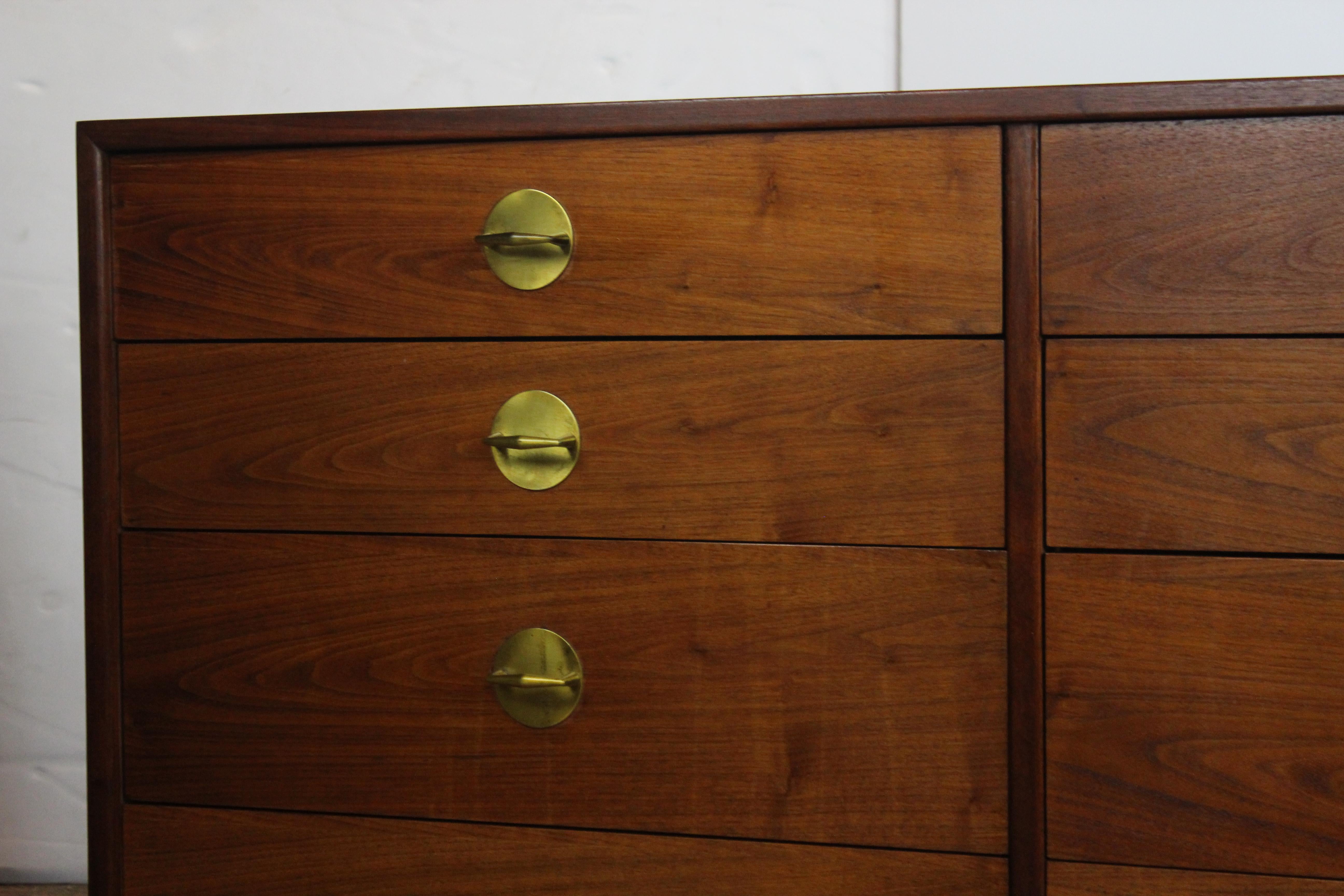 Pair of midcentury ten-drawer dresser, brass hardware sitting on a plinth base.