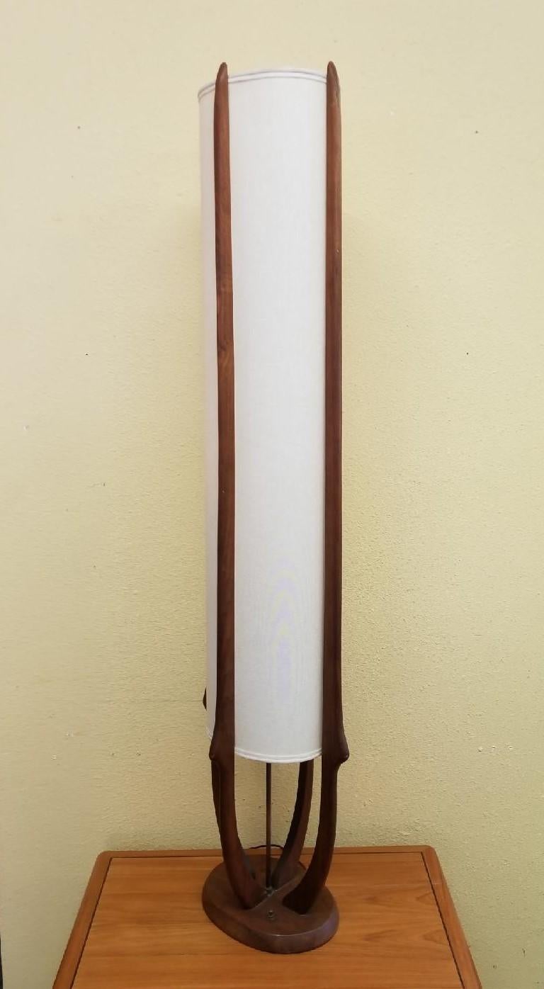 A very rare midcentury walnut floor lamp by Modeline Lamp Co., circa 1960s. The lamp shade is oval with four walnut support beams running the vertical length of the piece. Hard to find lamp in very good vintage condition.