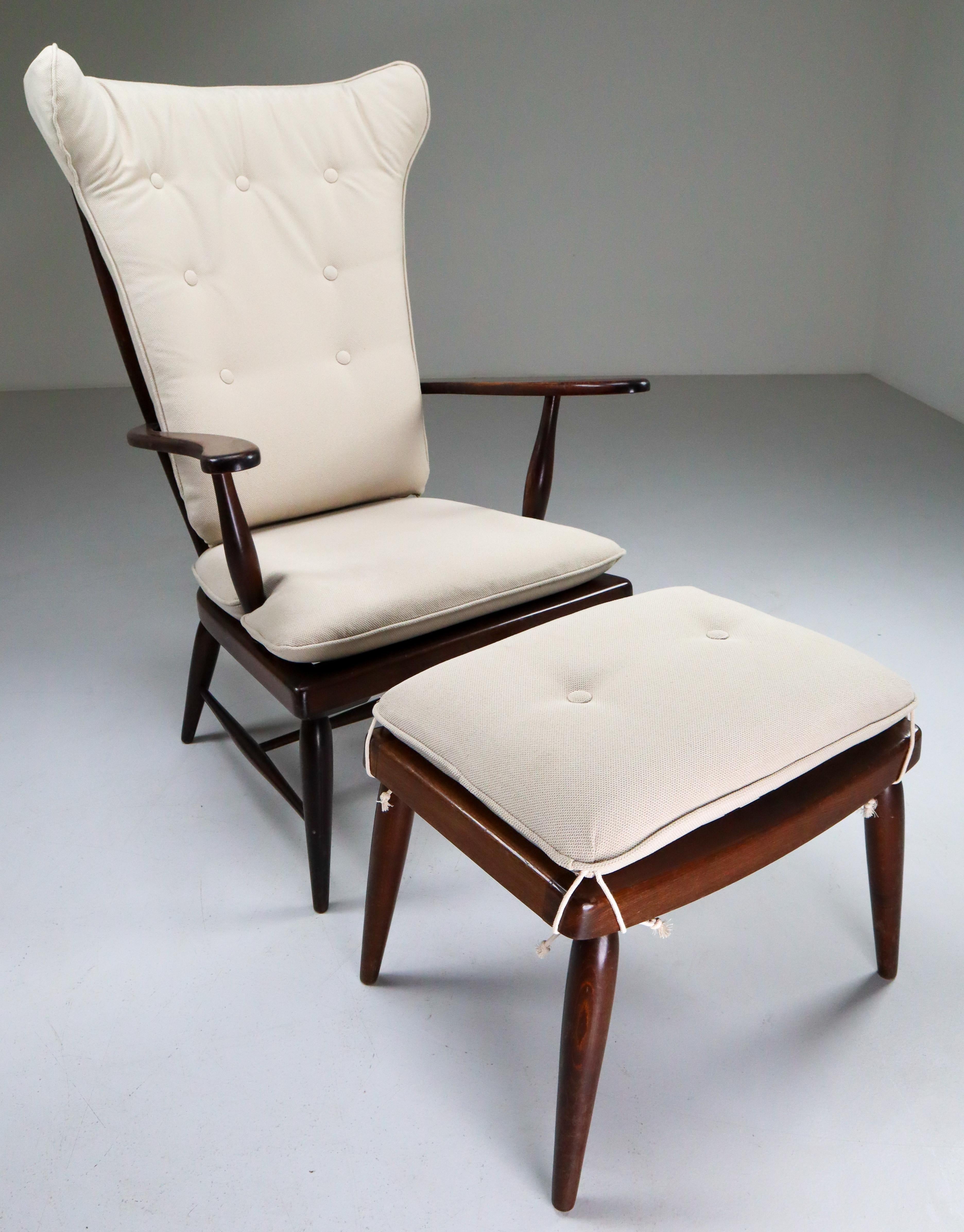 Beautiful pair of walnut high-back armchair and ottoman designed by Anna-Lülja Praun in 1950s. These armchair and ottoman has a solid walnut wood frame with reupholstered high quality cushions. These chair and ottoman is in a very good original