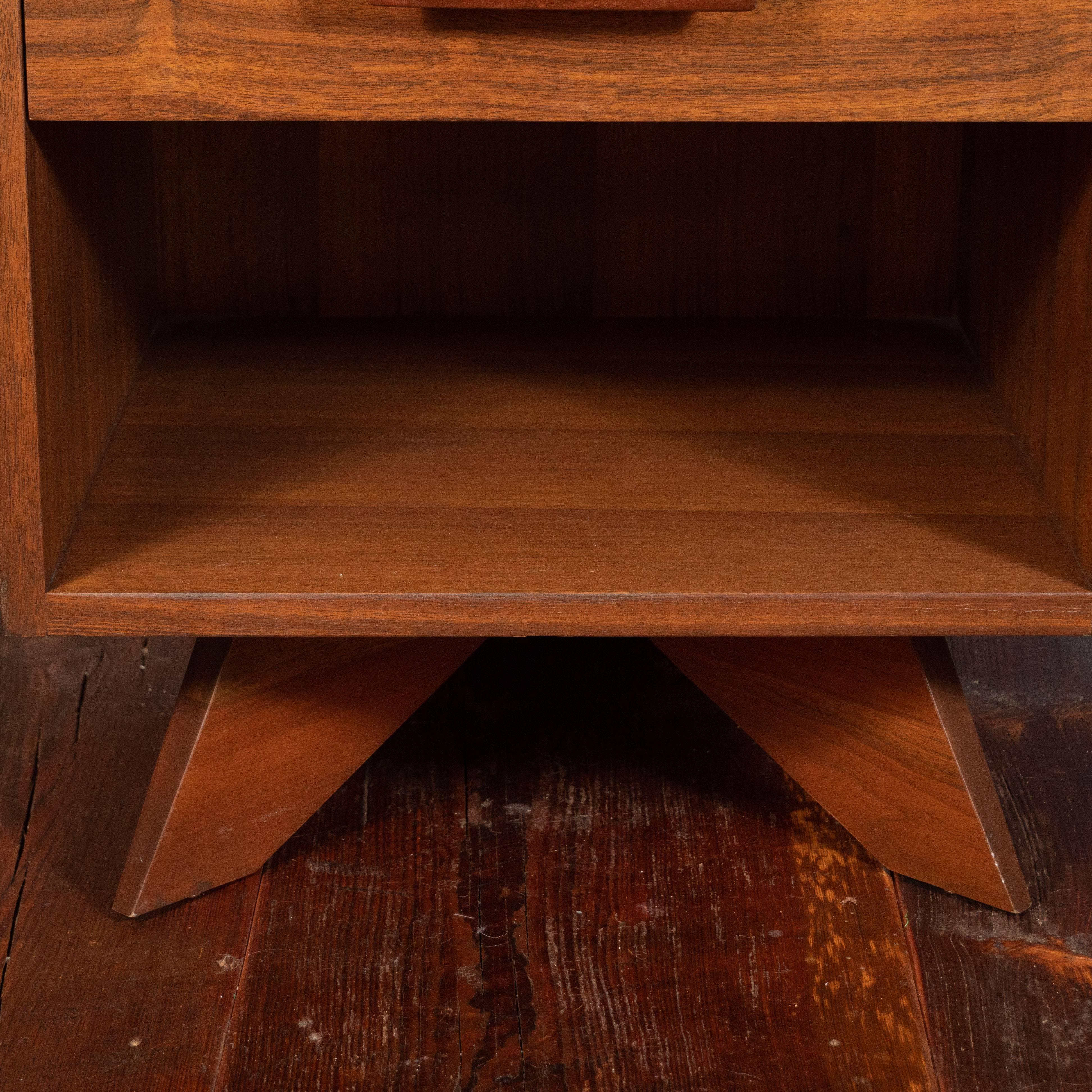 This American Mid-Century Modern nightstand or side table was designed in 1958 by George Nakashima (1905-1990) for his Origins Line, produced by the Widdicomb Furniture Company, Grand Rapids, Michigan. The nightstand or side table is in East Indian
