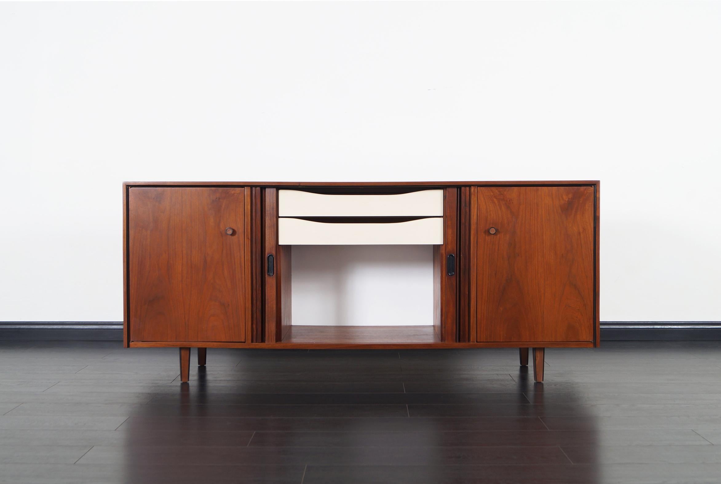 Mid-Century Modern walnut tambour door credenza by Dillingham. Features adjustable shelves on each end, the middle section of the piece has a series of two pull-out drawers behind the tambour doors.