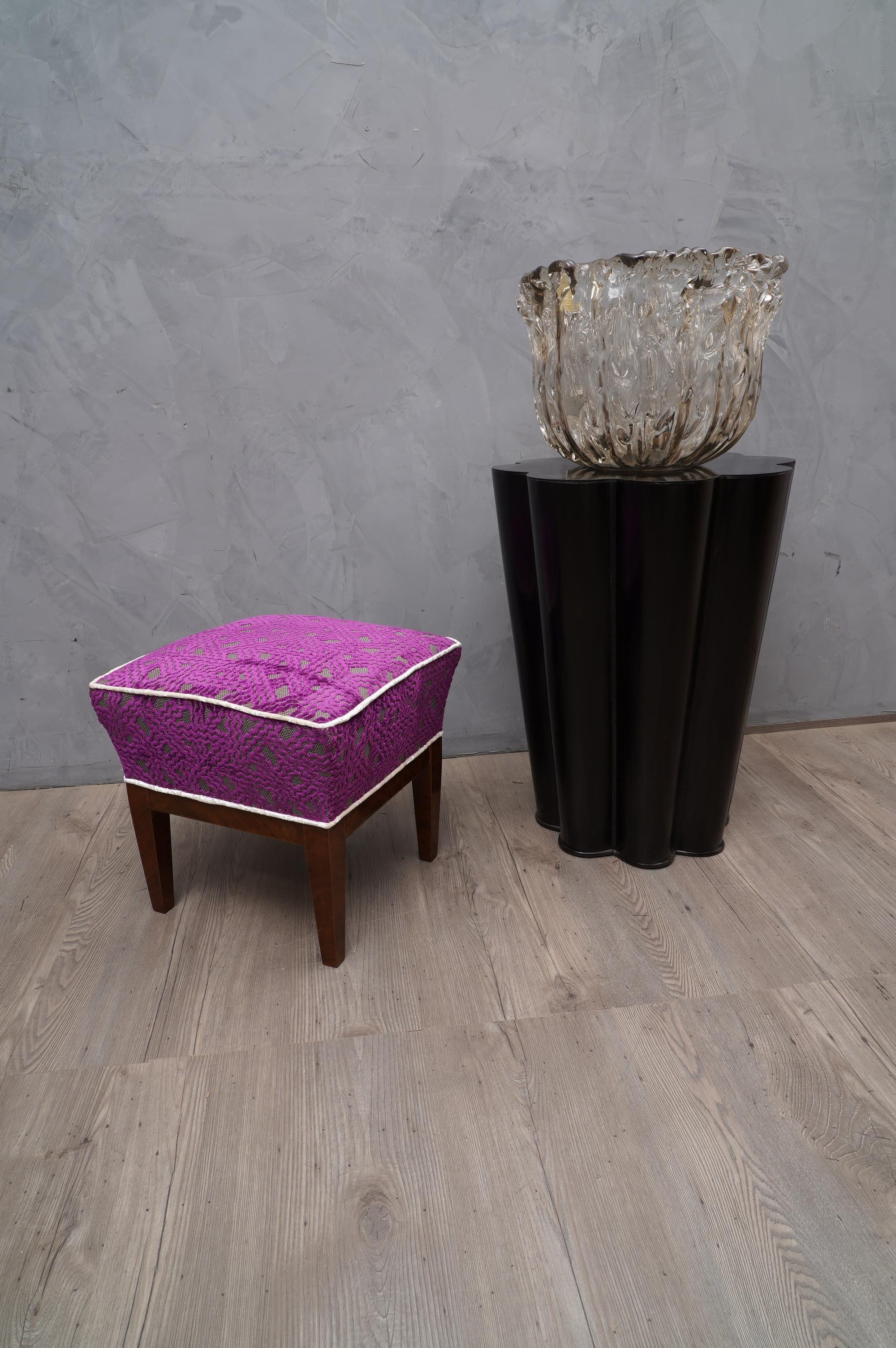 Adorable pouf with very simple shape embellished with a beautiful purple velvet fabric with geometric designs.

The structure of the pouf is in polished walnut wood with shellac; very beautiful and simple its design with four spiked legs. Above the