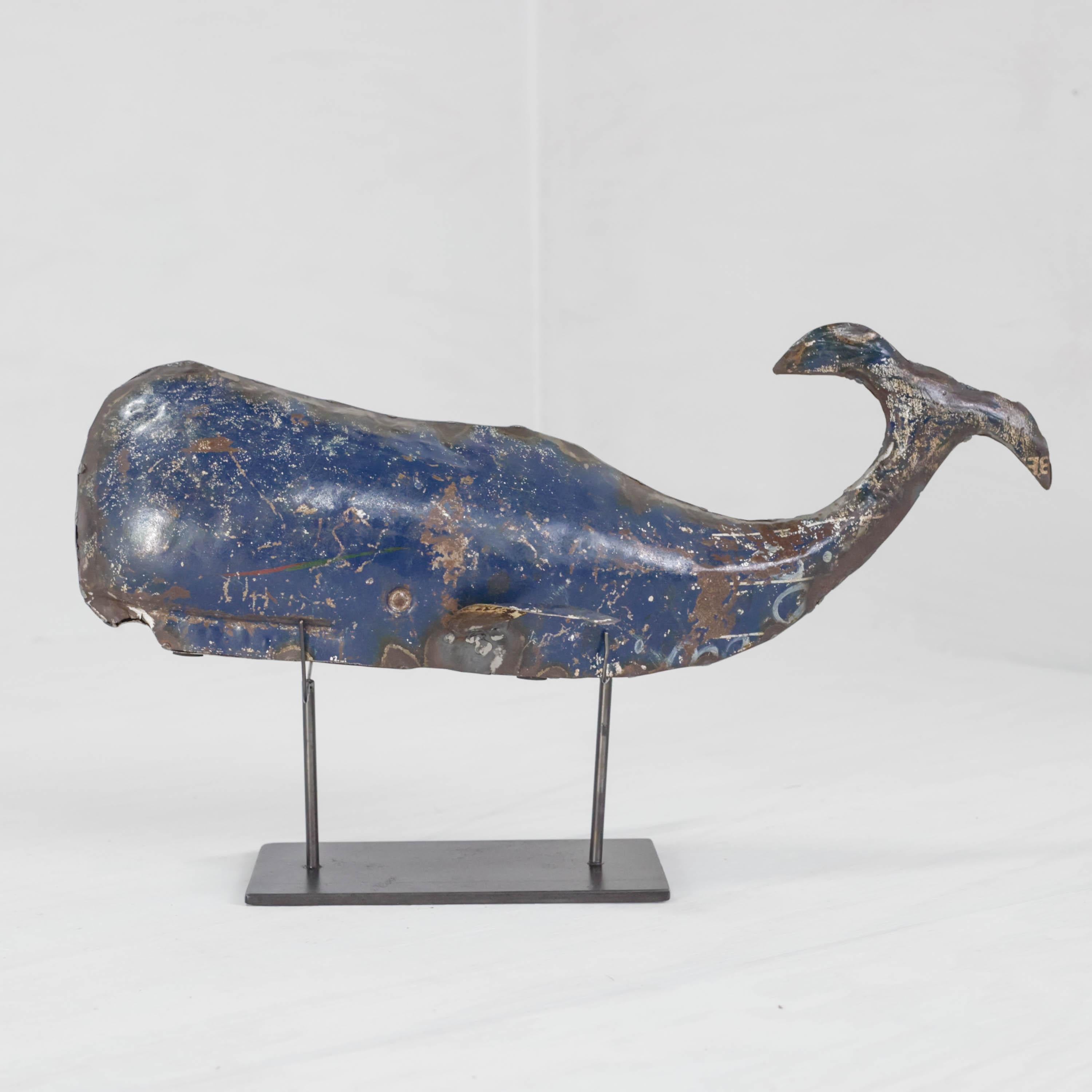This midcentury folk art sculpture features a cobalt blue sperm whale rendered in soldered tin, with lines that are both strong and graceful rests atop a simple, sturdy black steel base. 

Scrap tin was used in the creation of this one-of-a-kind