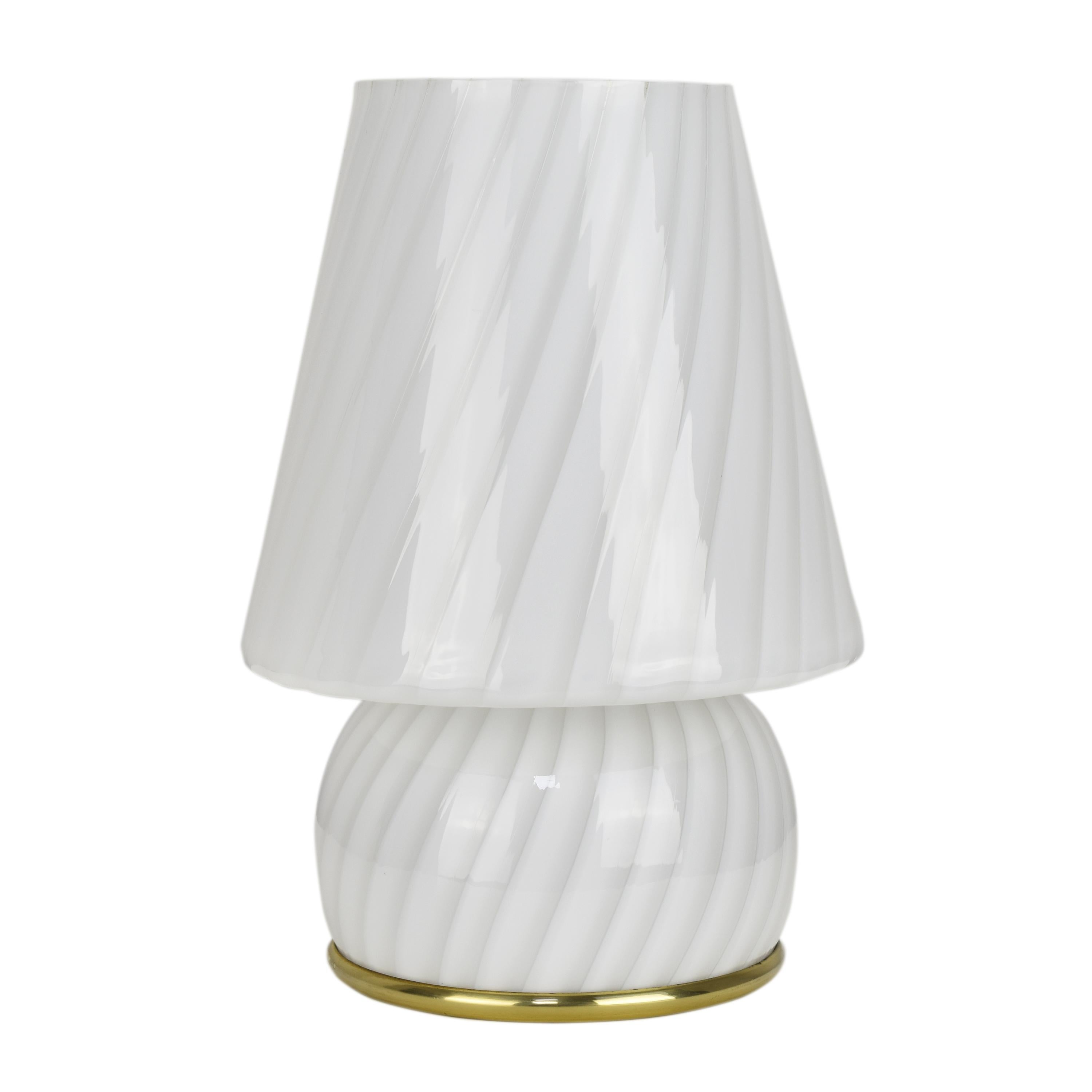 Lampe de table vintage en verre d'art de Murano, en forme de champignon, avec un tourbillon blanc, une pièce magnifique et artisanale du design d'éclairage, fabriquée dans les années 1960 par la société italienne Artemide. 
La lampe présente une