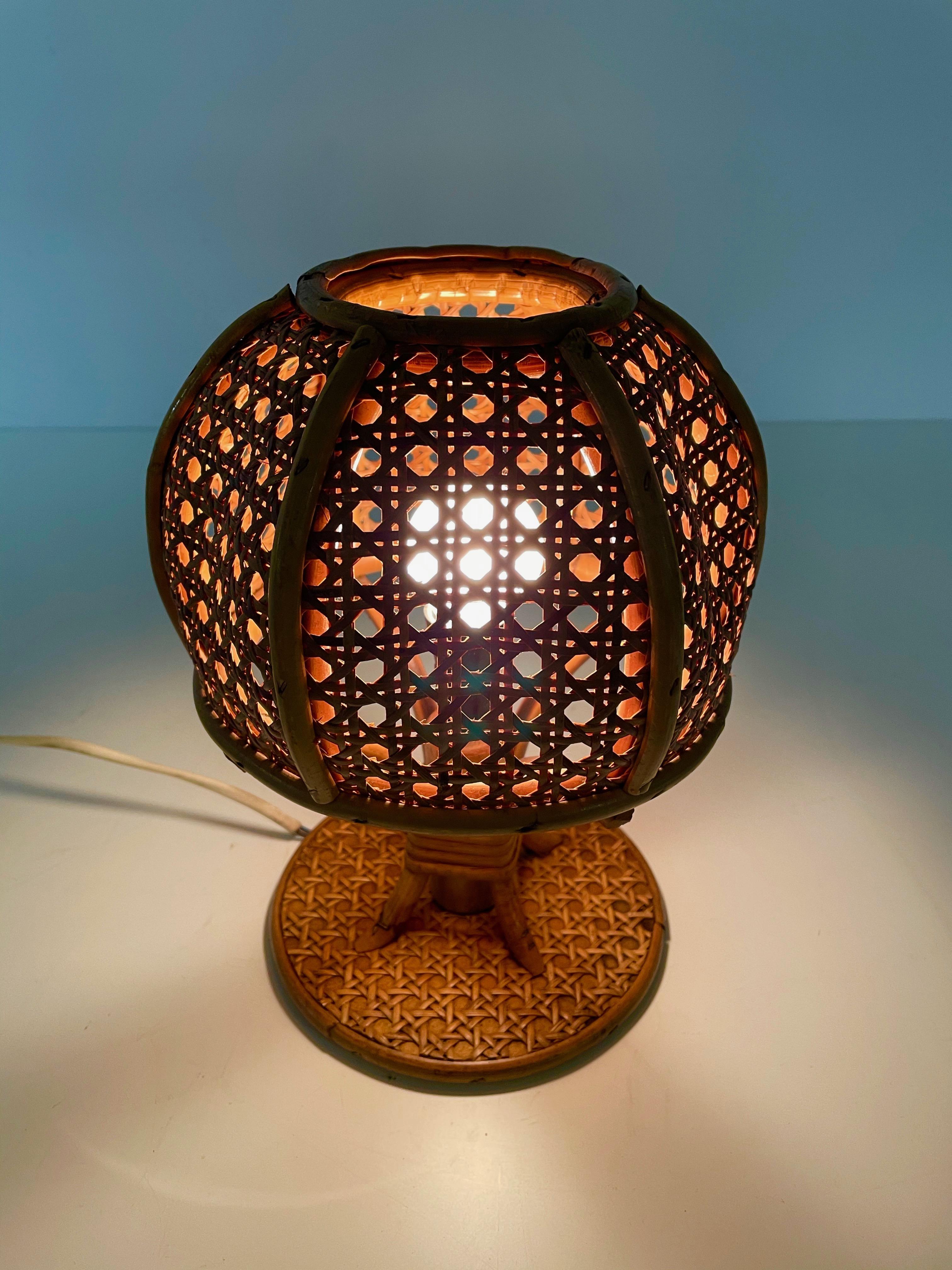 Amazing midcentury wicker and rattan table lamp. This fantastic piece was designed in Italy during the 1960s.

Having a wicker lampshade, the light diffusion is incredibly warm and sexy. This piece exudes Italian design and materials from the