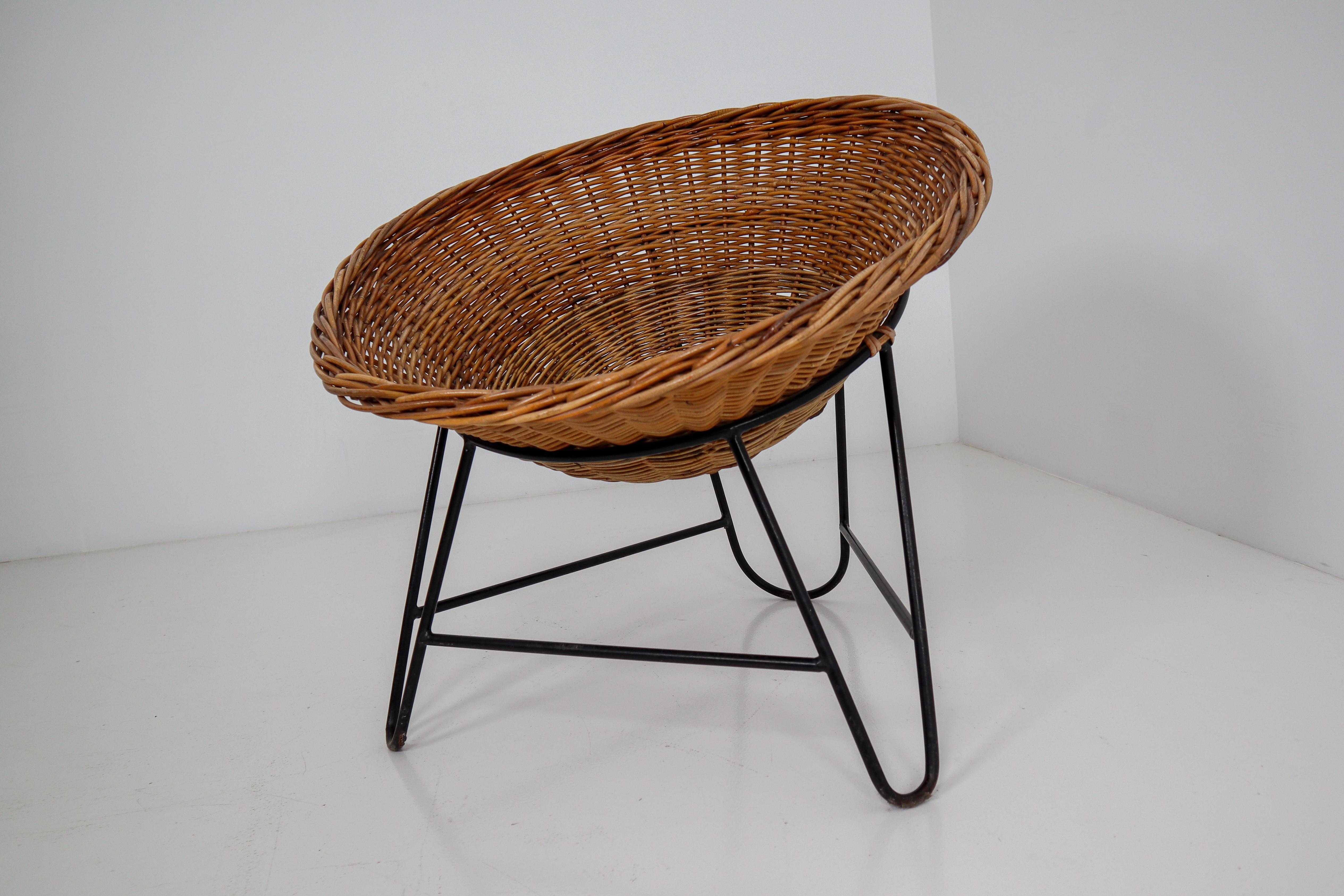 Large set wicker midcentury easy chairs designed and produced in Europe during the 1960s. The chairs are made from handwoven wicker for the seat that is formed into a basket. The frame is made of black lacquered steel. They are comfortable to sit in