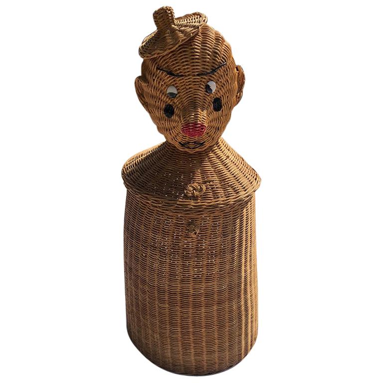 Whimsical midcentury handcrafted natural wicker clown or tin man basket, hamper or planter with lifelike dimensional had eyes, nose, and bowtie. Complete with metal button eyes and painted nose. This beauty is sturdy and stands upright. He is round