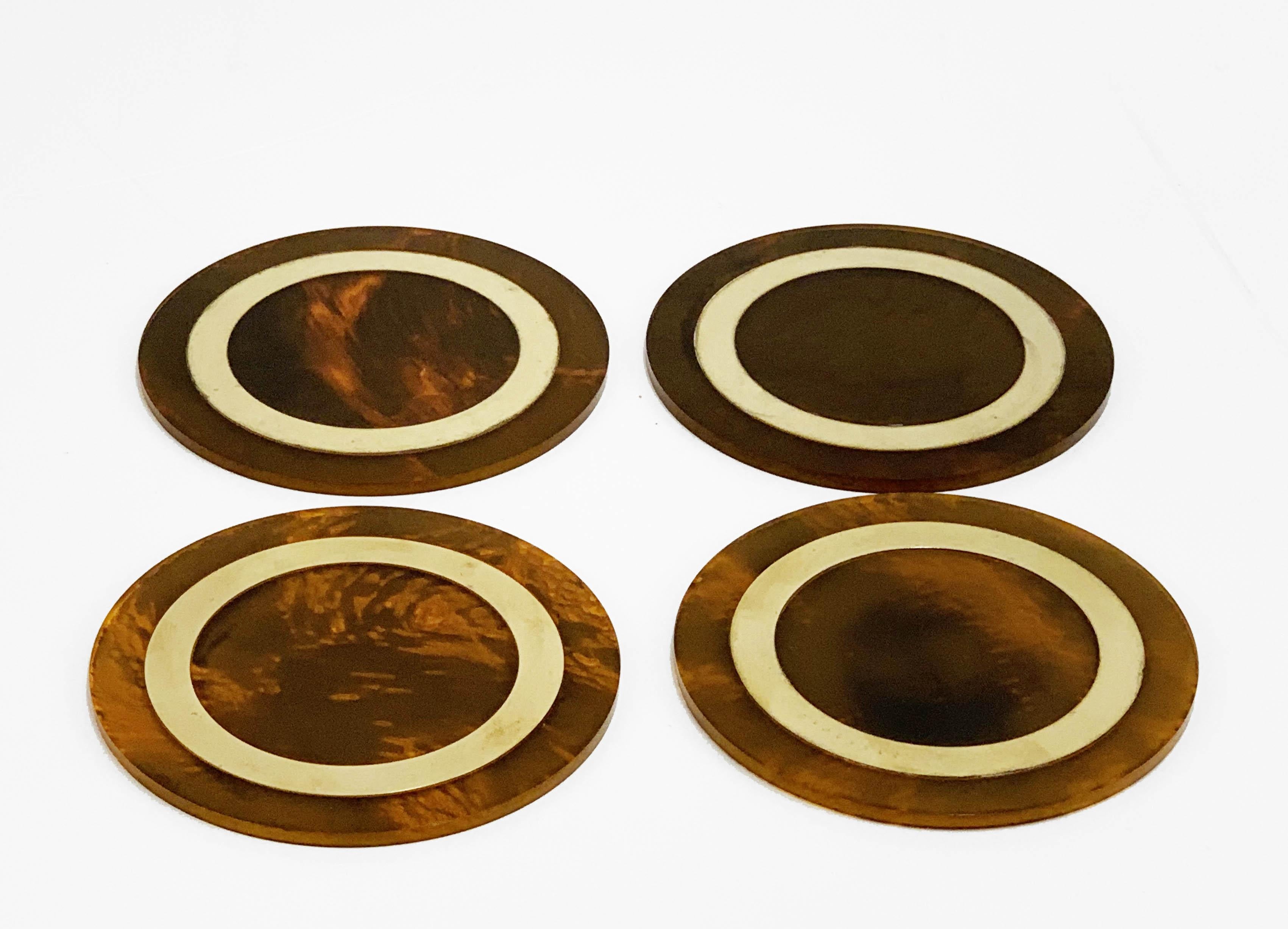 Wonderful set of 4 midcentury coasters in tortoiseshell plexiglass and brass. This set was produced in Italy, during 1970s.

The brass round element enlights the contract with the tortoiseshell plexiglass. 

An elegant set that will decorate a