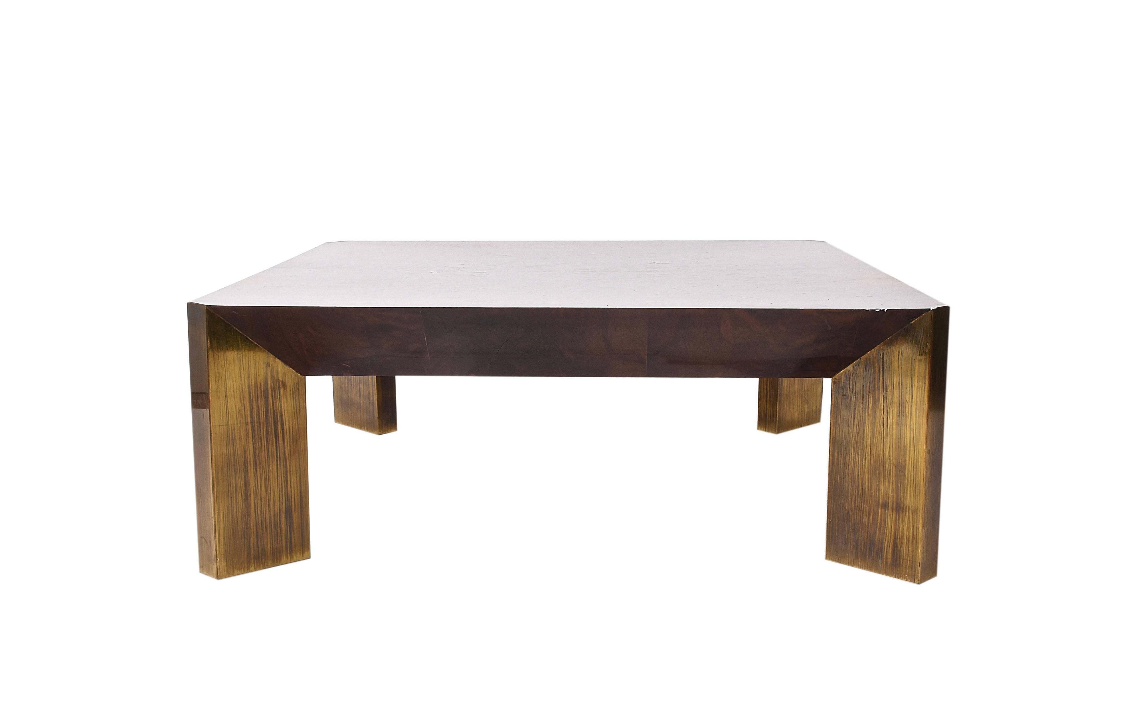 Amazing midcentury coffee table covered in walnut, it was produced in Italy during 1970s. 

The legs are just extraordinary, as they are covered with brass plates, enhancing the straight lines of these elements.

The perfect piece for a