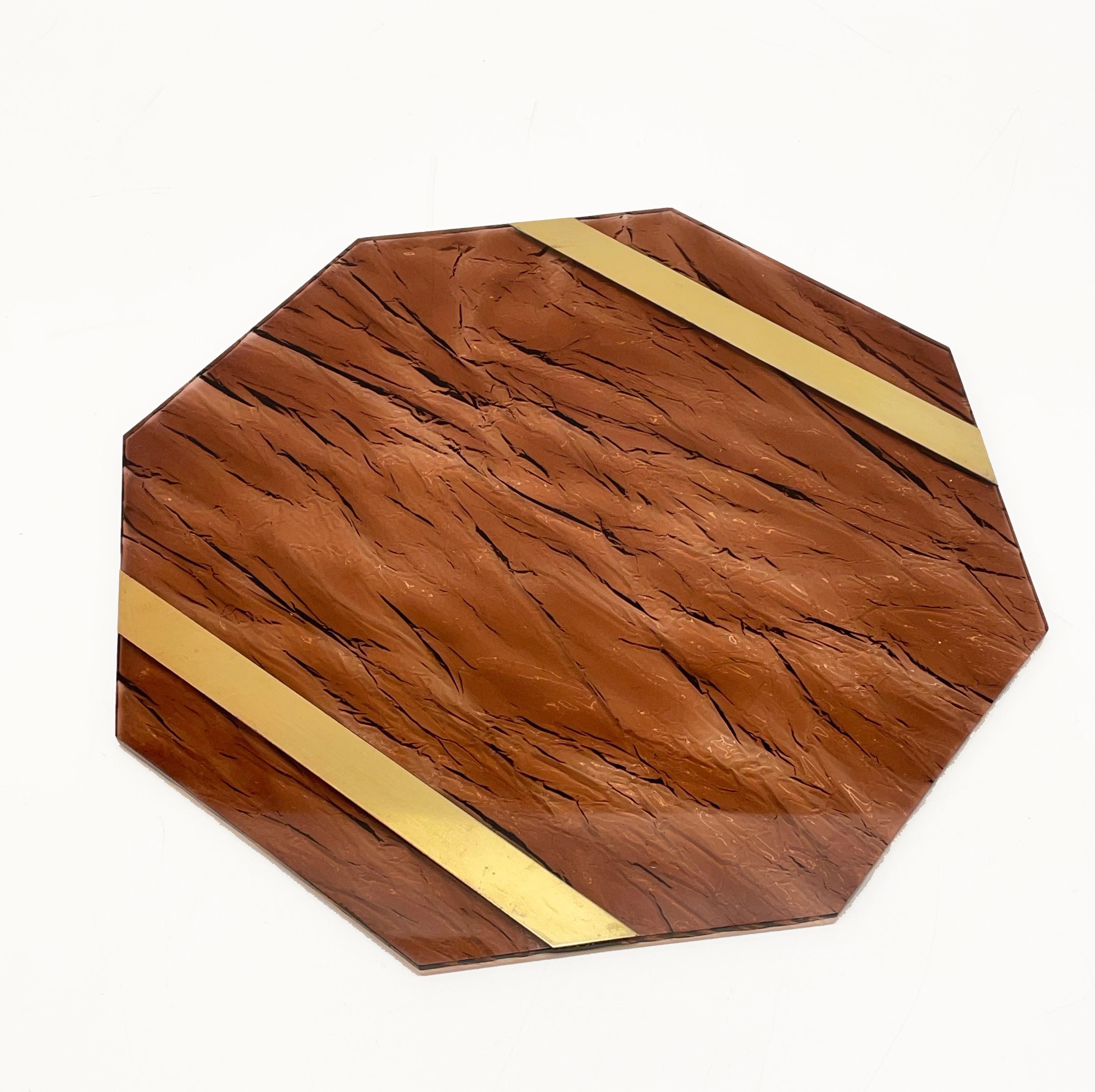 Octagonal placemat in plexiglass with smoked ice effect and brass. This piece was designed by Willy Rizzo in Italy during the 1970s.

This piece is made with two parallel brass bands in between tortoiseshell plexiglass elements.

This piece is
