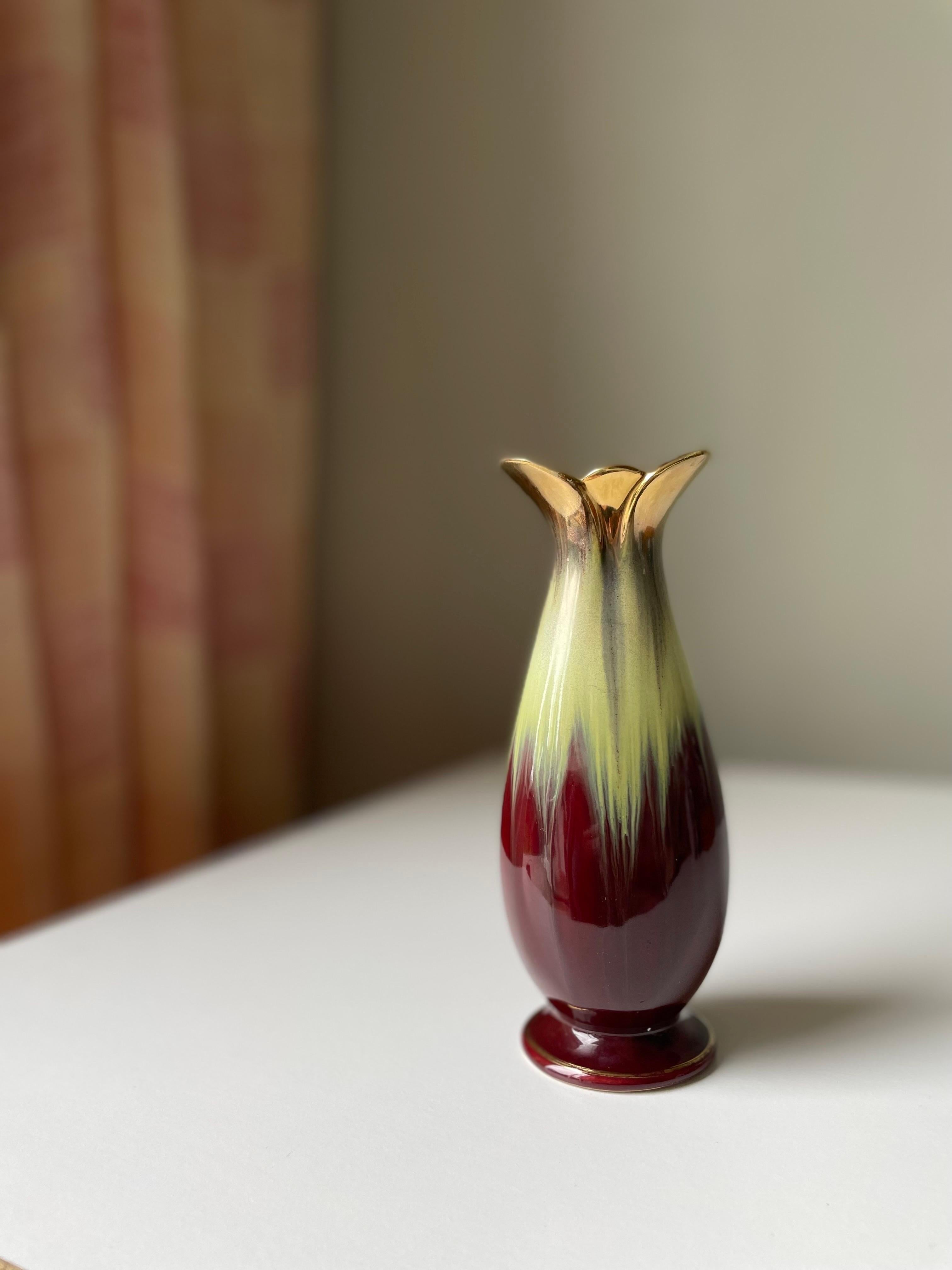 Midcentury decorative piece with shiny burgundy and lime running glaze. Golden round base and leaf shaped top on the organic floral like shape. Original label under base. Manufactured by Bay Ceramics in Germany in the 1960s. Beautiful vintage