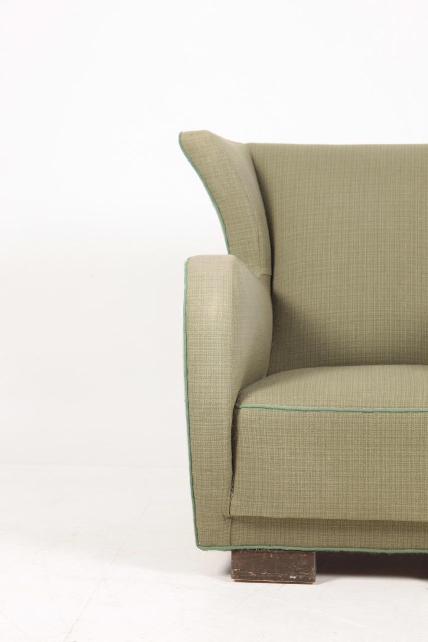 Wingback chair upholstered in fabric. Designed and made in Denmark.