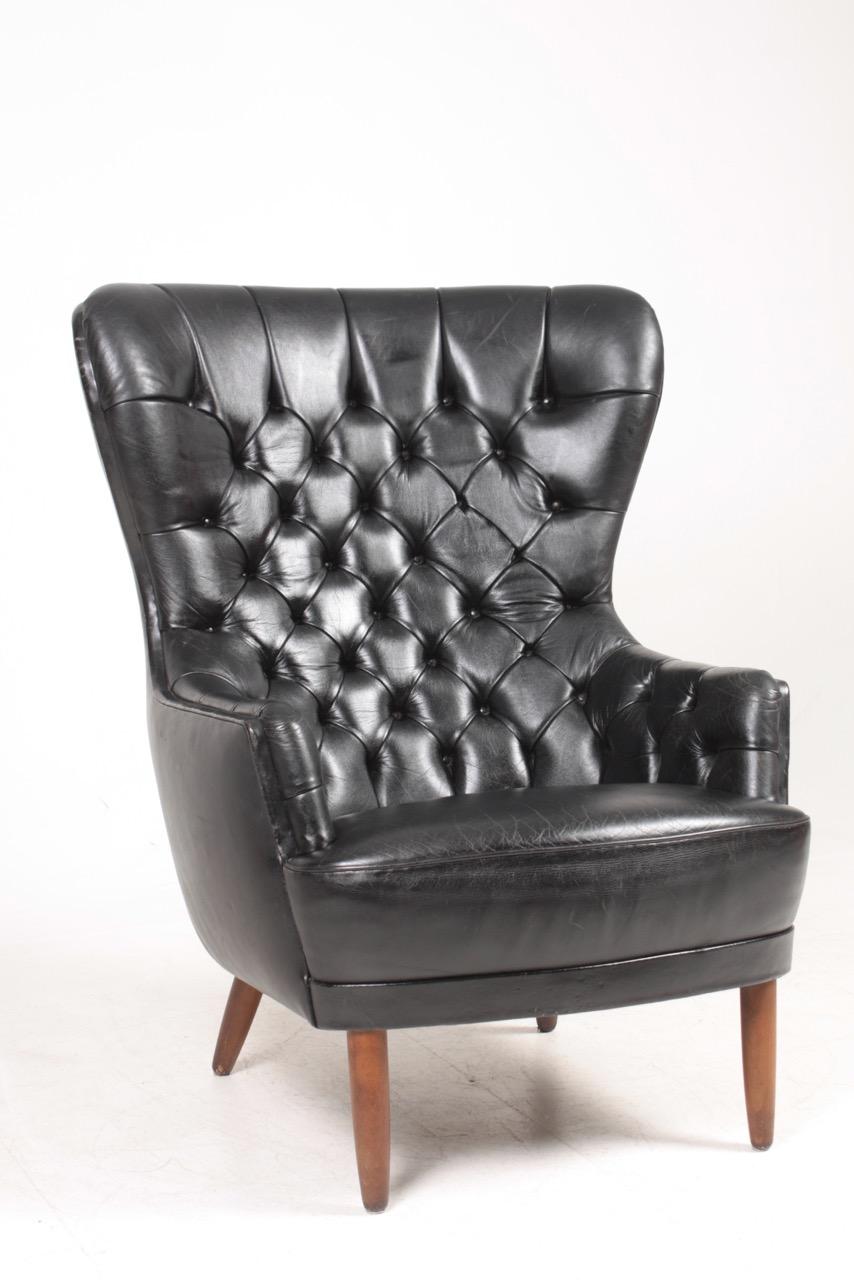 Great looking wingback chair in patinated leather, designed and made in Denmark.
