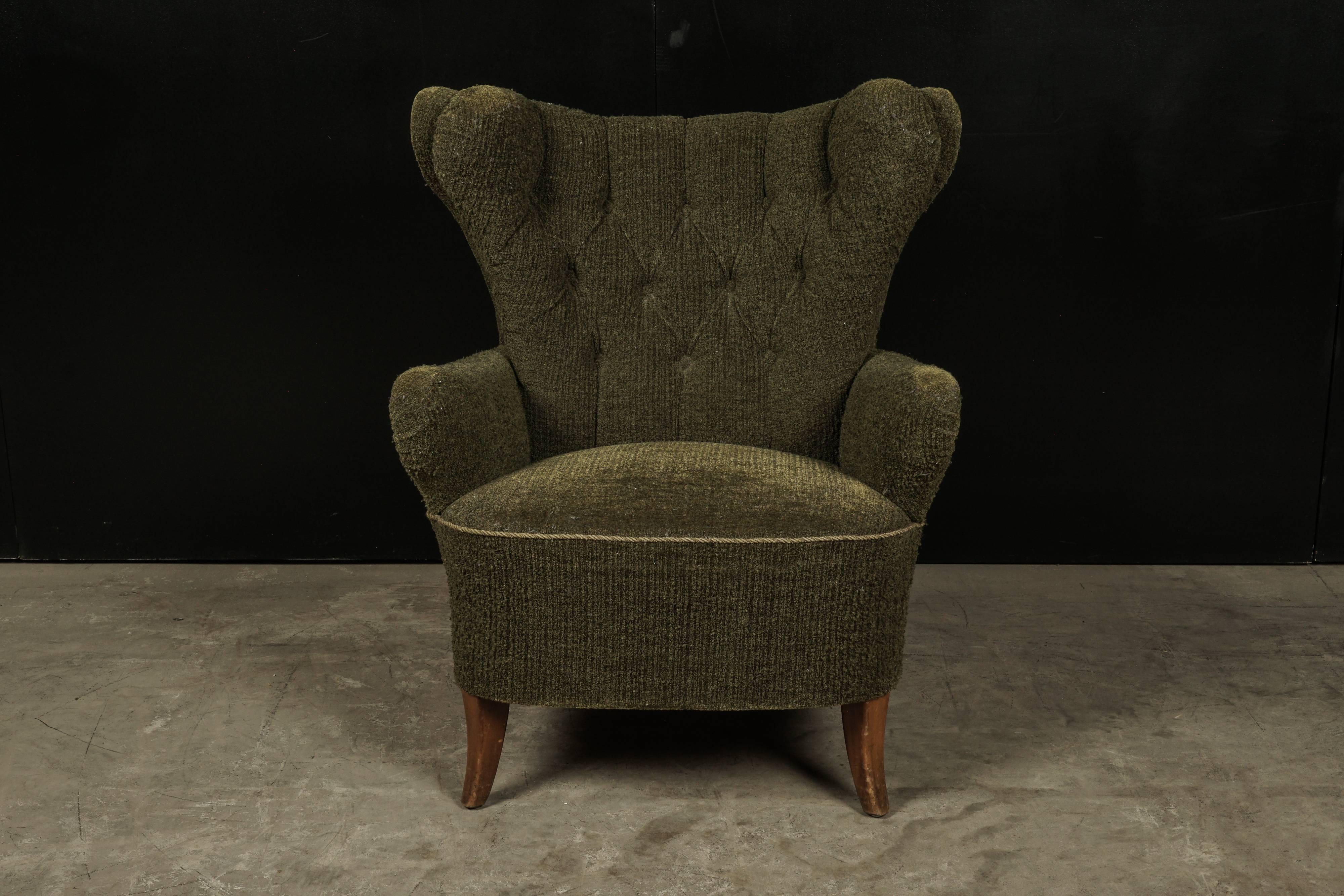 Midcentury wingback chair from Denmark, circa 1960. Original green upholstery with stained beech legs.
