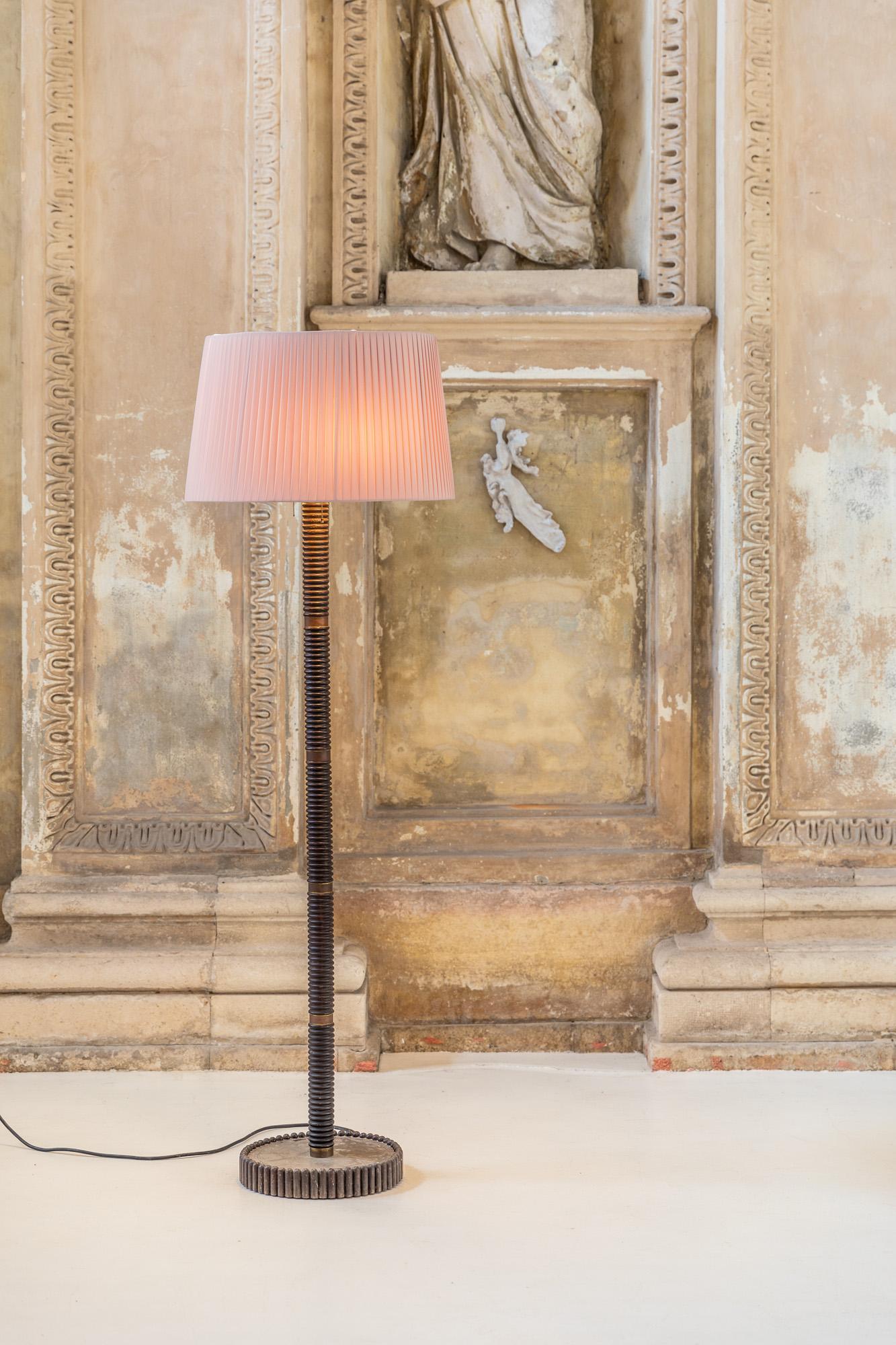 Elegant lampadaire avec structure en bois et laiton, fabriqué en Italie dans les années 40.
Cache-lampes à deux ampoules avec un abat-jour en tissu plissé rose monté sur un pied de lampe et une tige finement décorés.
