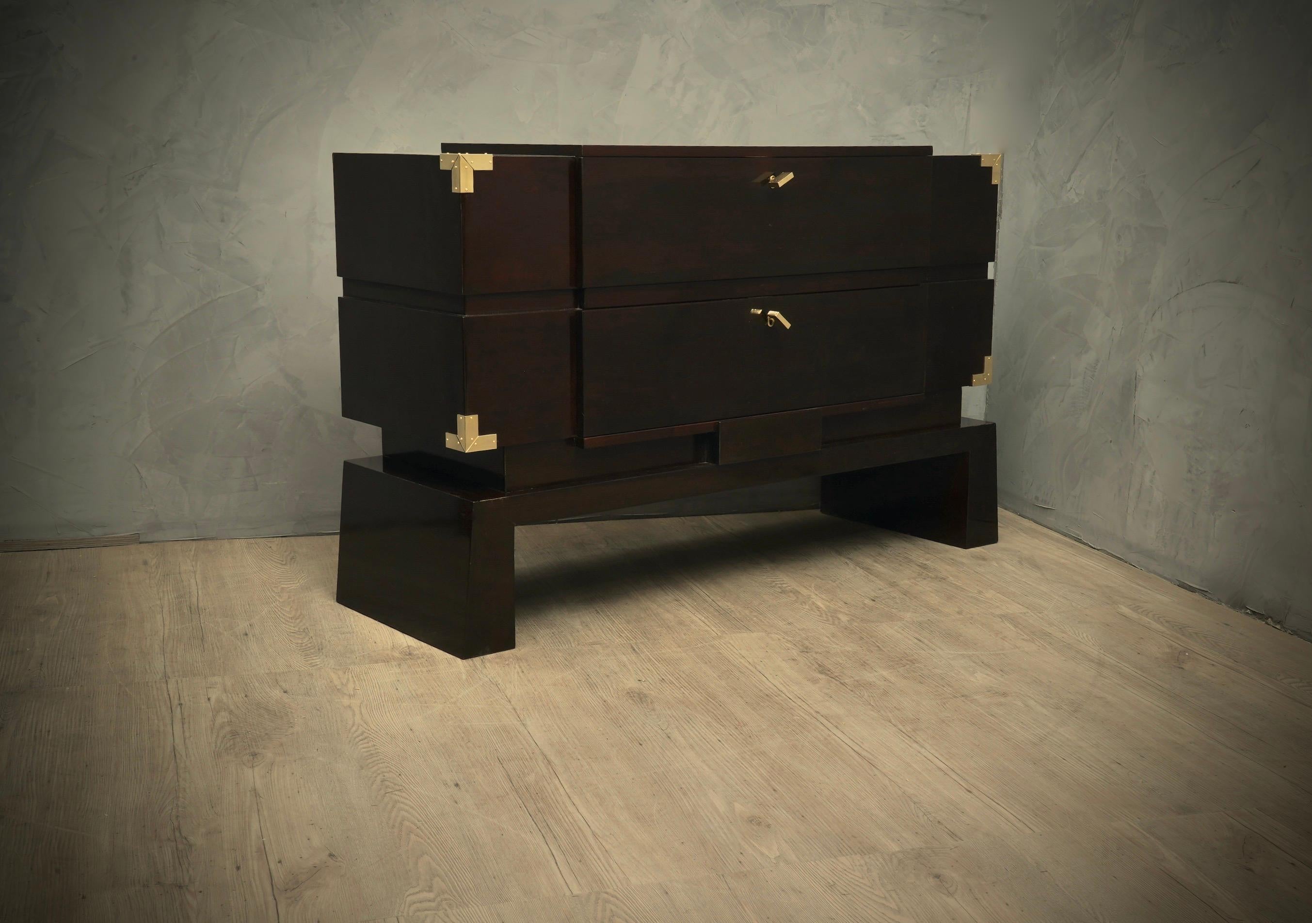 Beautiful and elegant dresser both for its articulated movement and for the perfect shellac polishing. The brass finishes match his style perfectly.

The chest of drawers is veneered in dark mahogany stained walnut wood, with a perfect shellac