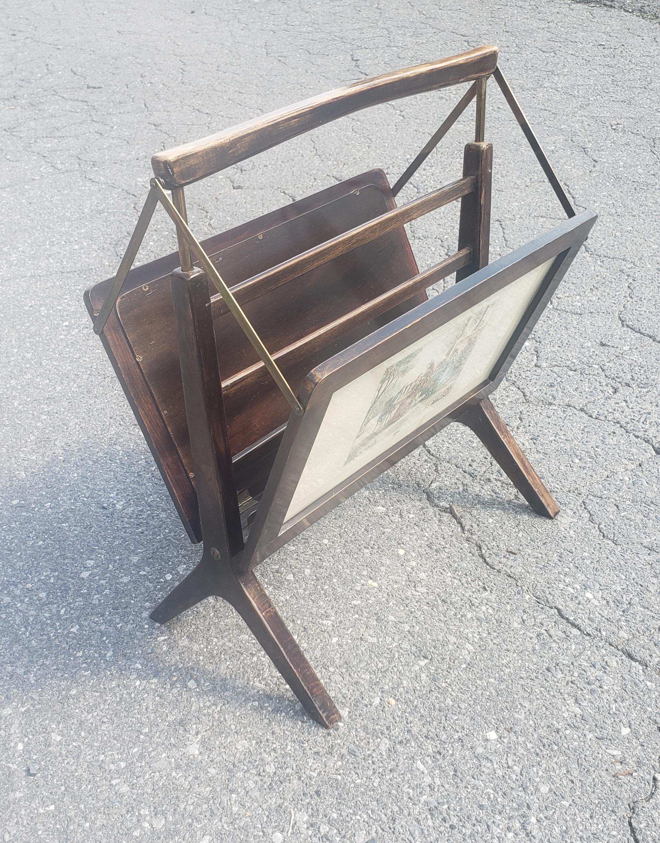Midcentury wood and brass Italian magazine rack in the Ico Parisi style. Enclosed prints on both side with various scenes. Measures 19