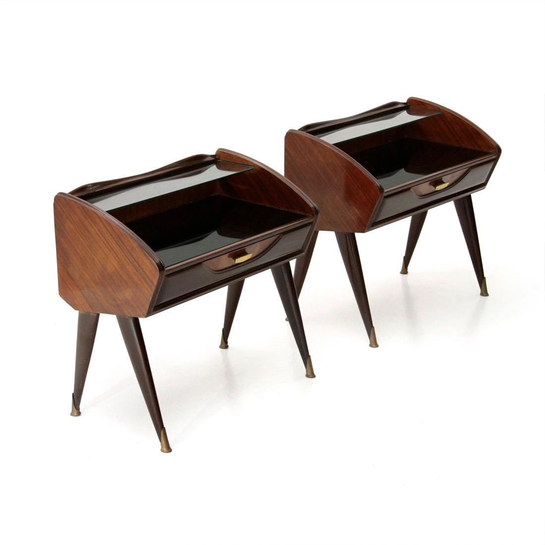 Pair of Italian-made bedside tables produced in the 1950s.
Structure in veneered wood.
Front drawer with brass handle.
Black glass top and transparent glass shelf.
Wooden legs with final tapering.
Brass tips.
Good general conditions, some