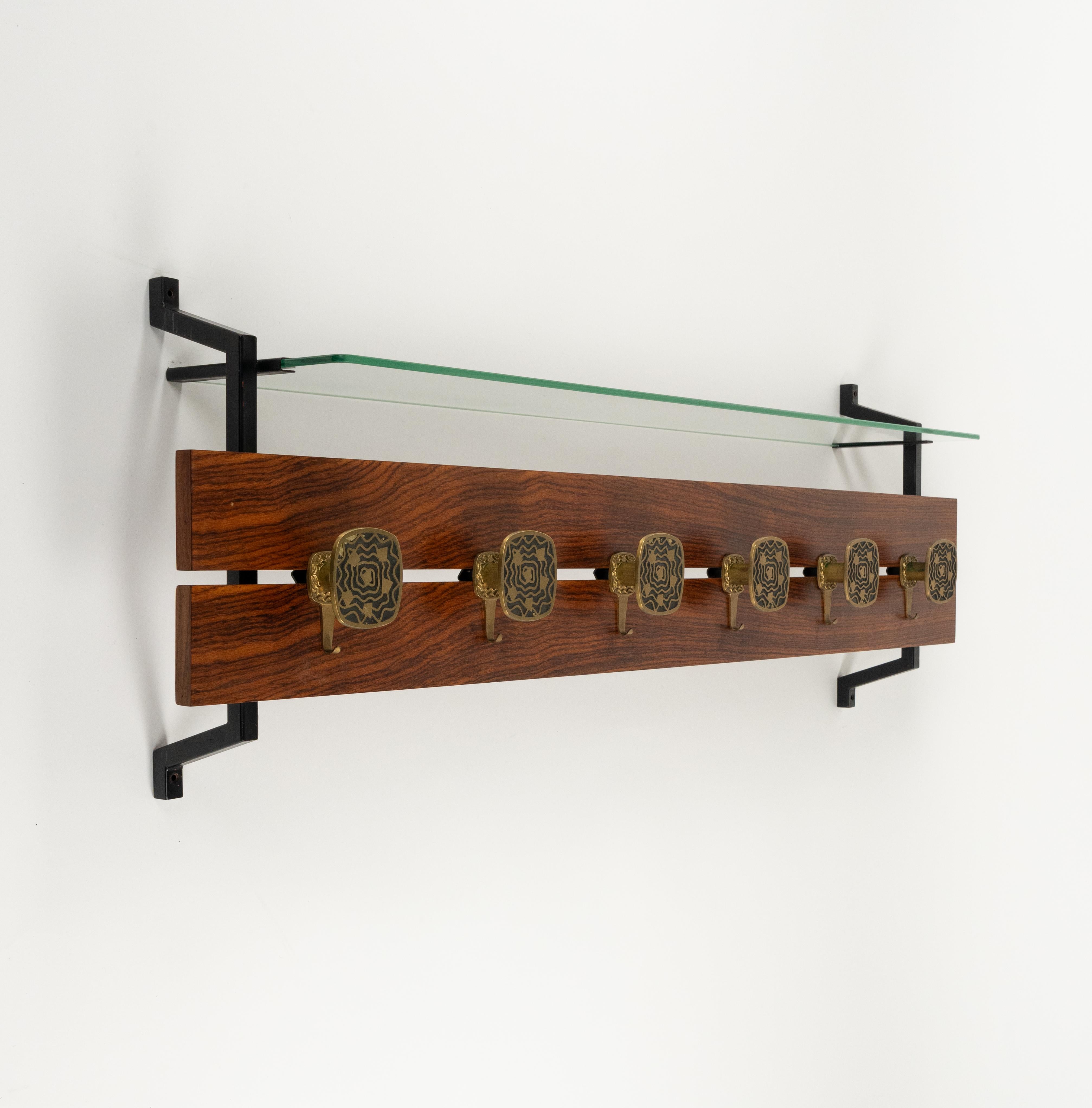 Midcentury amazing large wall coat rack in wood, glass top shelf and six hooks in brass  in the style of Walter Bosse and Herta Baller.

Made in Italy in the 1970s.