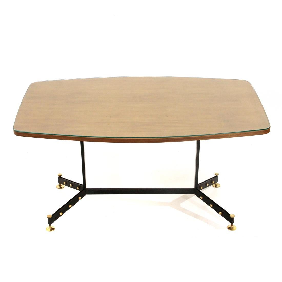 Italian-made dining table produced in the 1950s.
Rectangular top with convex long sides and rounded corners in veneered wood and transparent glass.
Structure in black painted metal with brass studs.
Height adjustable feet in brass.
Good general