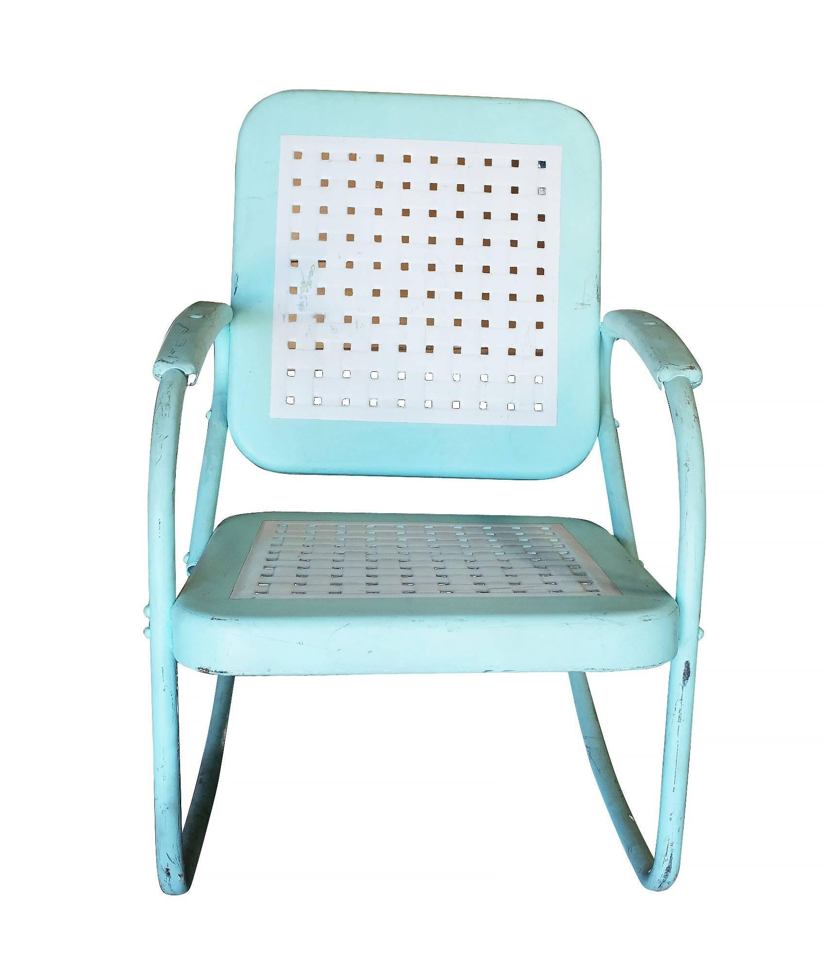 Midcentury Woodard style garden outdoor rocking chair made from a stamped sheet metal seat and a tubular steel frame. There is a unique woven basket design along the top of each seat.