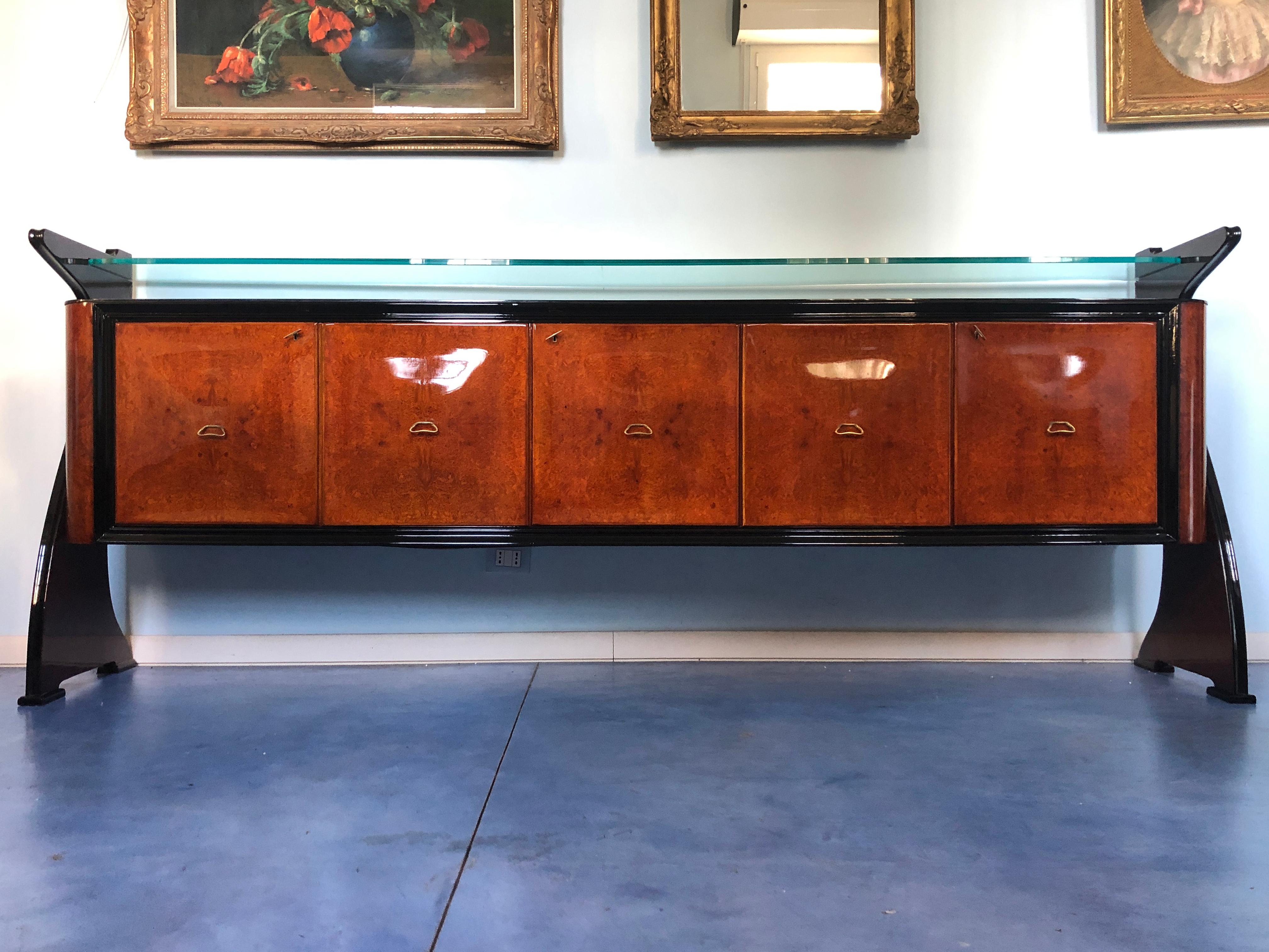 Fine Italian sideboard Guglielmo Ulrich's style.
Amboyna and rosewood, stunning line sides, rare black opaline glass top, ebonized details and mahogany interiors.
Recently restored and ready to use.

If requested, we'll provide the CITES