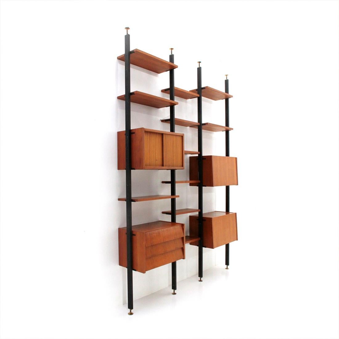 Italian-made bookcases produced in the 1960s.
Uprights in painted metal with adjustable brass terminals.
Wall units in teak veneered wood.
11 shelves.
A container compartment with sliding doors.
Two compartments with flap opening, one with red