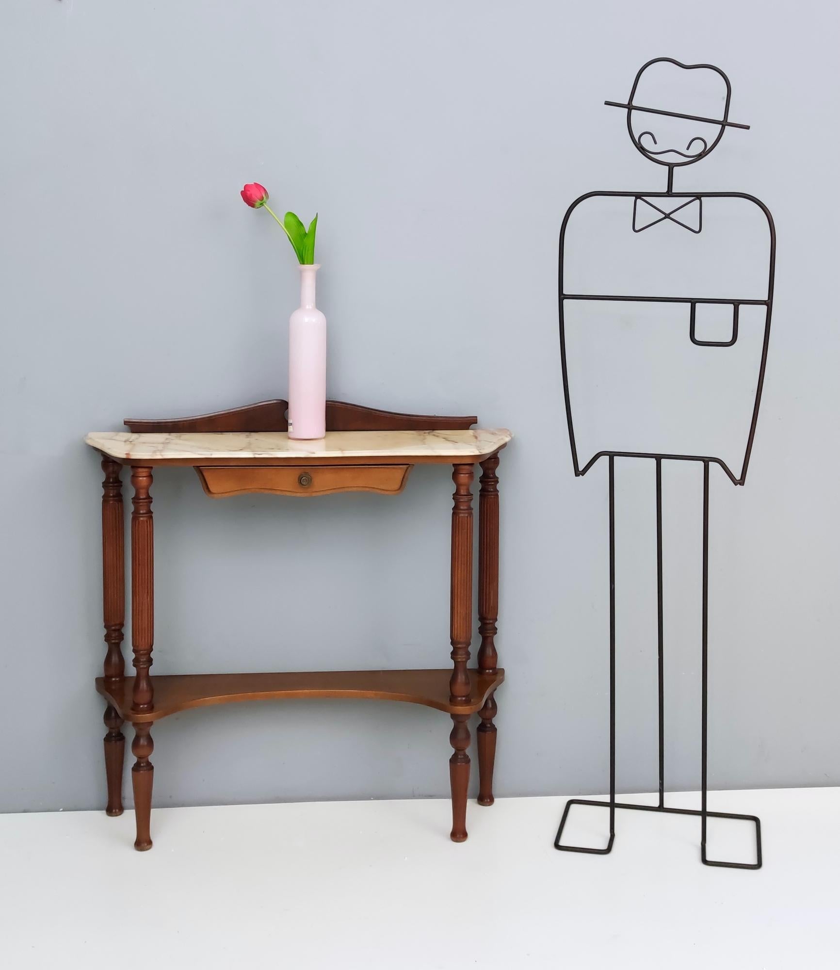 Italy 1970s.
This console table features a Portuguese pink marble top, a walnut frame, turned legs and a bronze handle.
It is a vintage item, therefore it might show slight traces of use, but it can be considered as in very good original condition