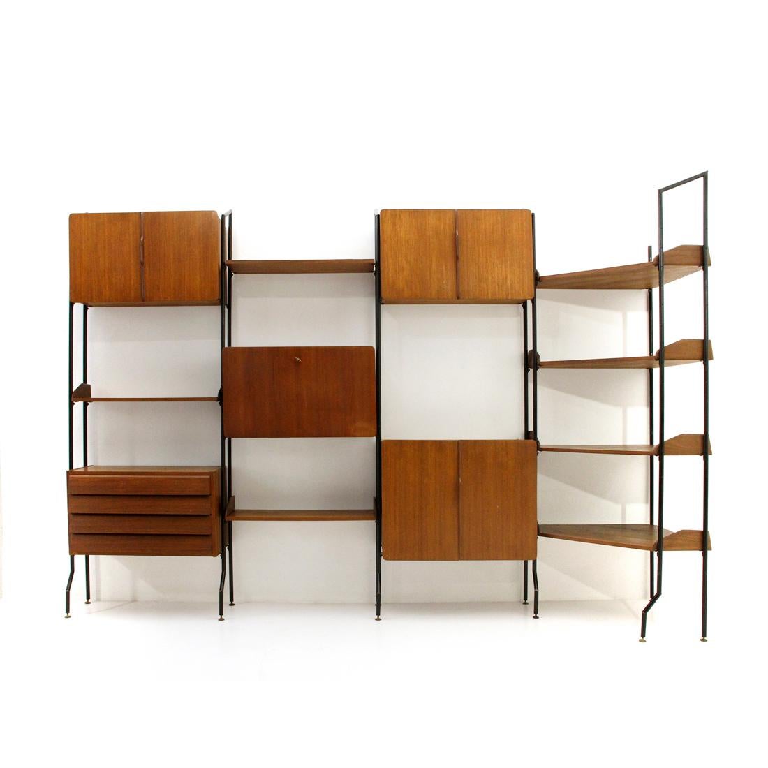 Italian manufacture bookcase produced in the 1950s.
Uprights in black painted metal with height-adjustable brass feet.
Storage compartments and shelves in teak veneered wood.
Door handles in shaped wood.
Drawers with recessed handle.
Container