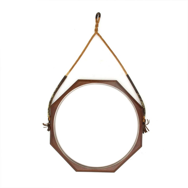 Italian manufacture mirror produced in the 1960s.
Octagonal wooden frame.
Mirrored glass surface.
Brass hooks.
Fabric rope with leather details.
Good general conditions, some signs due to normal use over time.

Dimensions: Width 58 cm, height