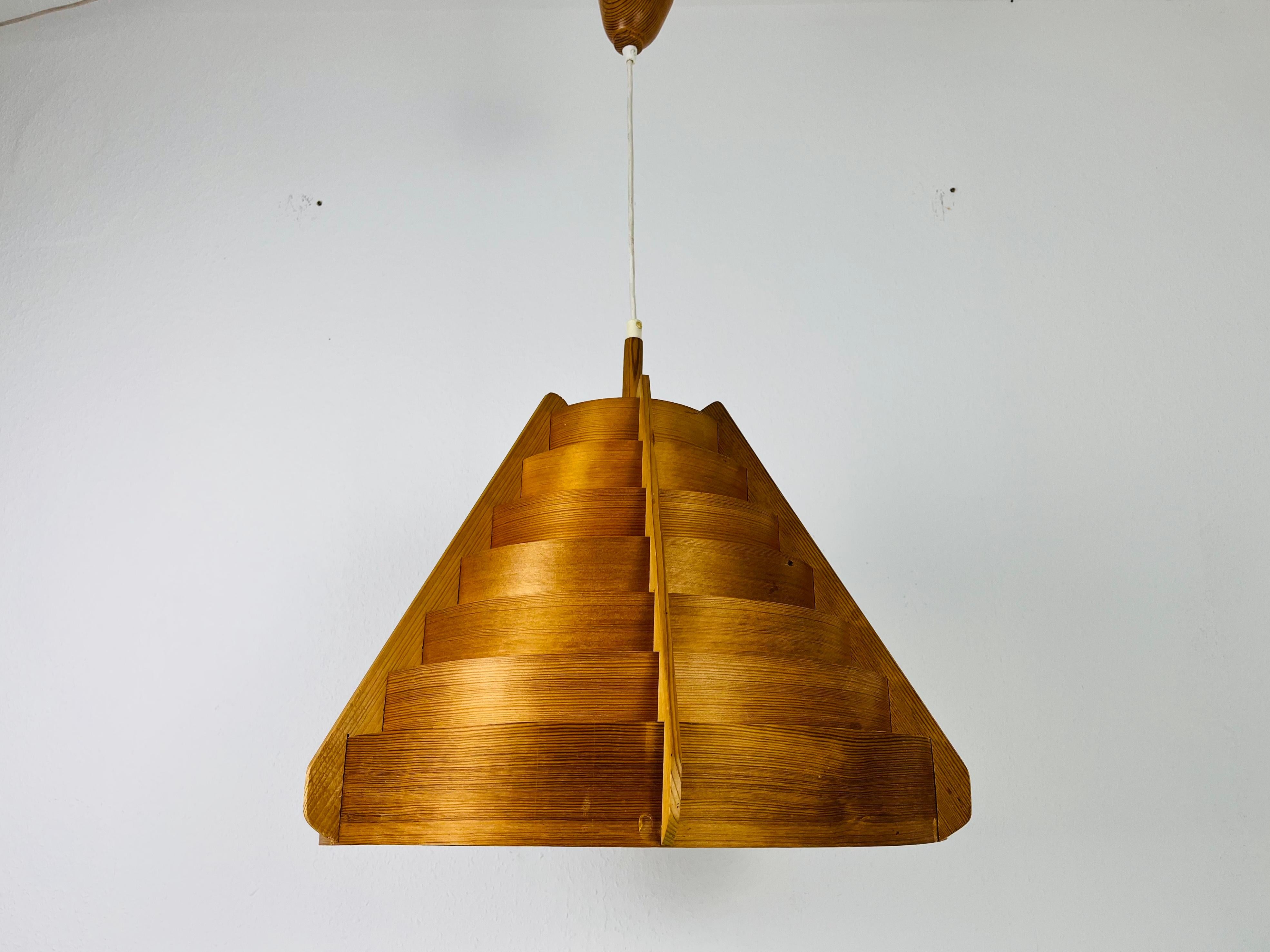 Eine hölzerne Hängeleuchte von Hans-Agne Jakobsson aus den 1960er Jahren. Der Korpus der Lampe ist aus Holz. Die Lampe hat ein schönes skandinavisches Design.

Abmessungen:
Höhe: 47-100 cm
Durchmesser: 53 cm

Die Leuchte benötigt eine