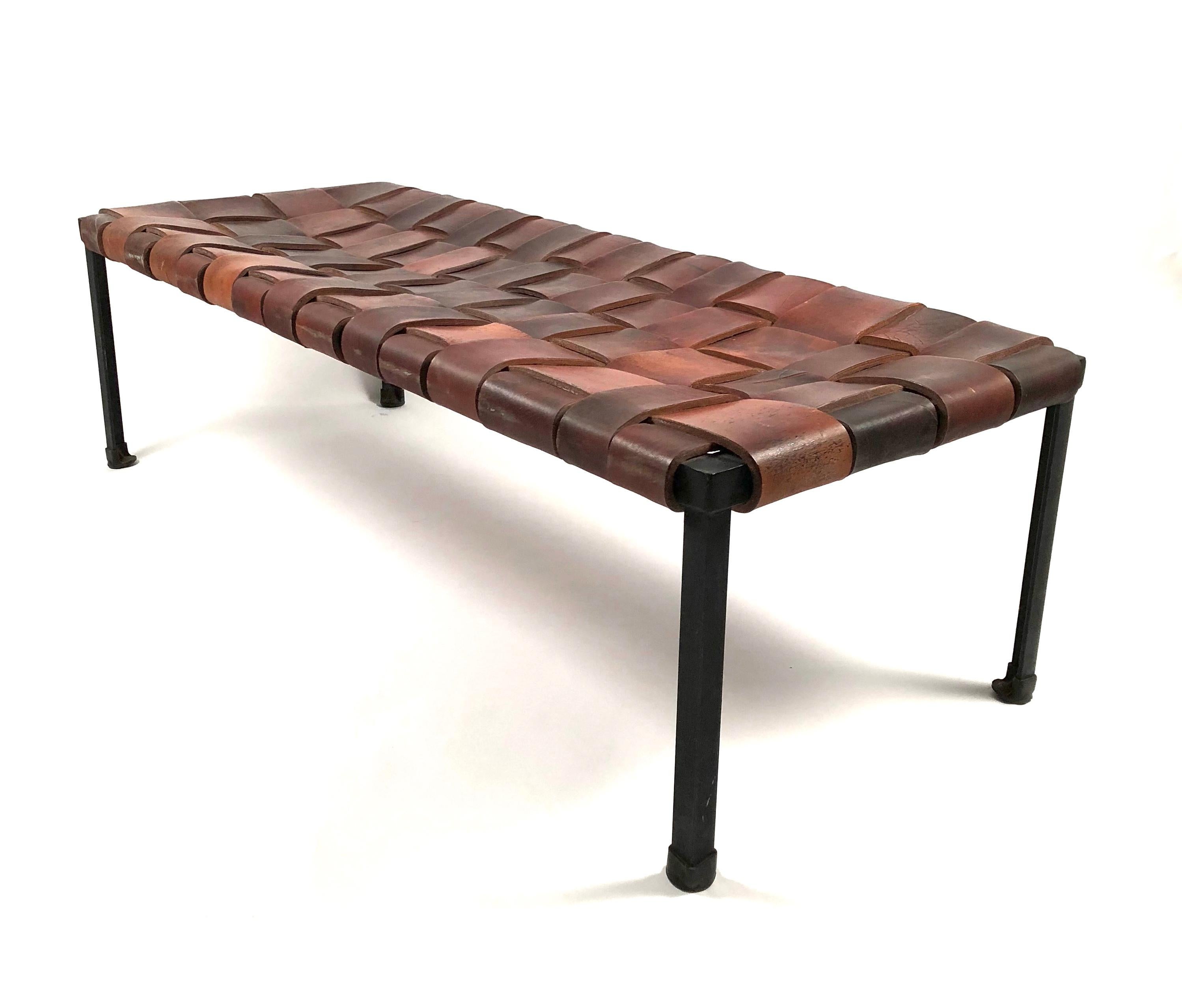 A rare and beautifully made rectangular bench with thick woven leather top and wrought iron square section legs with rubber pad feet by Donald Monnell and Lila Swift. Swift and Monnell pieces are very rare to the market. Their designs were exhibited