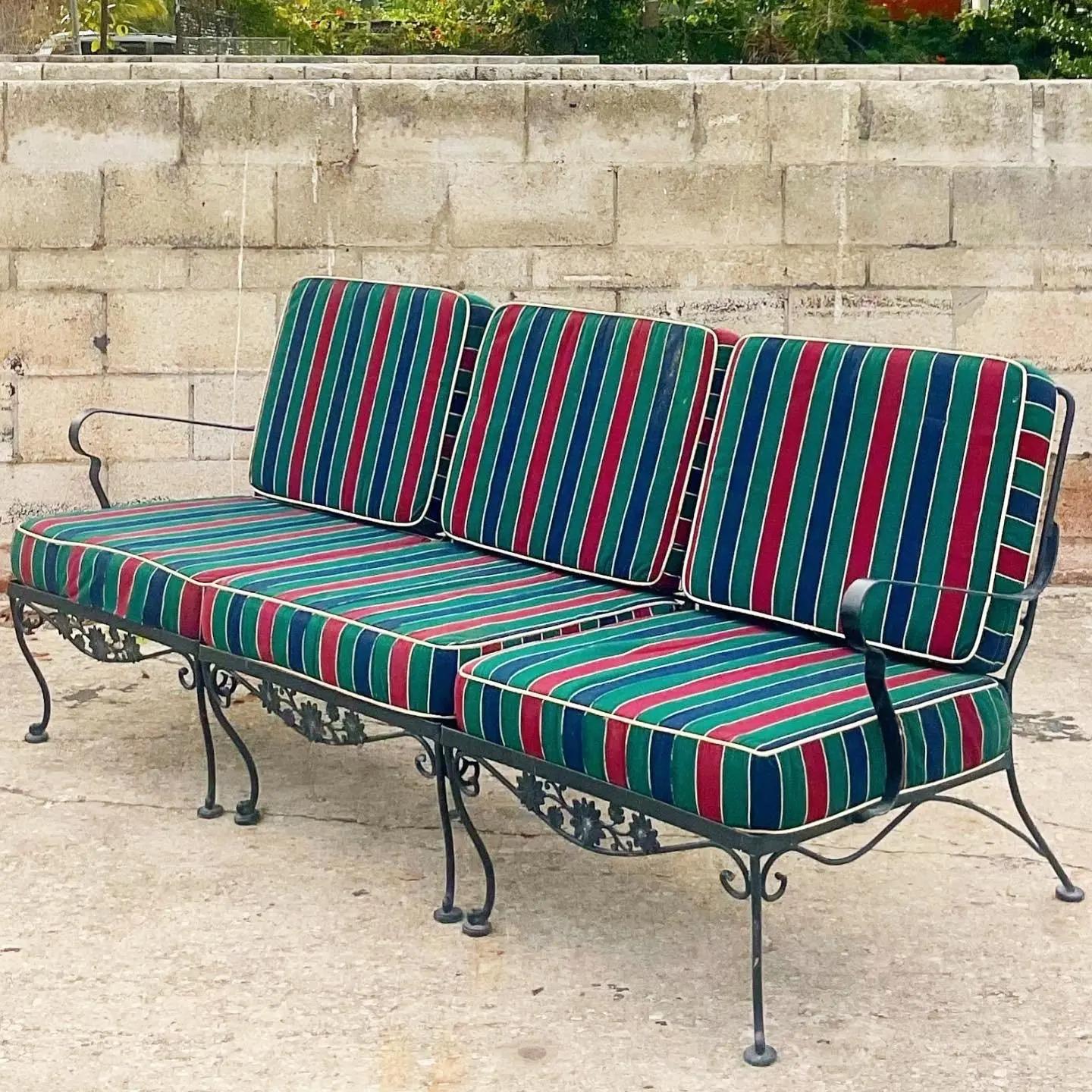 Fantastic vintage wrought iron sofa. Done in the manner of Russell Woodard. Three separate pieces are used to create this one sofa. Excellent set of striped cushions in deep rich colors. Acquired from a Palm Beach estate.

The sofa is in great