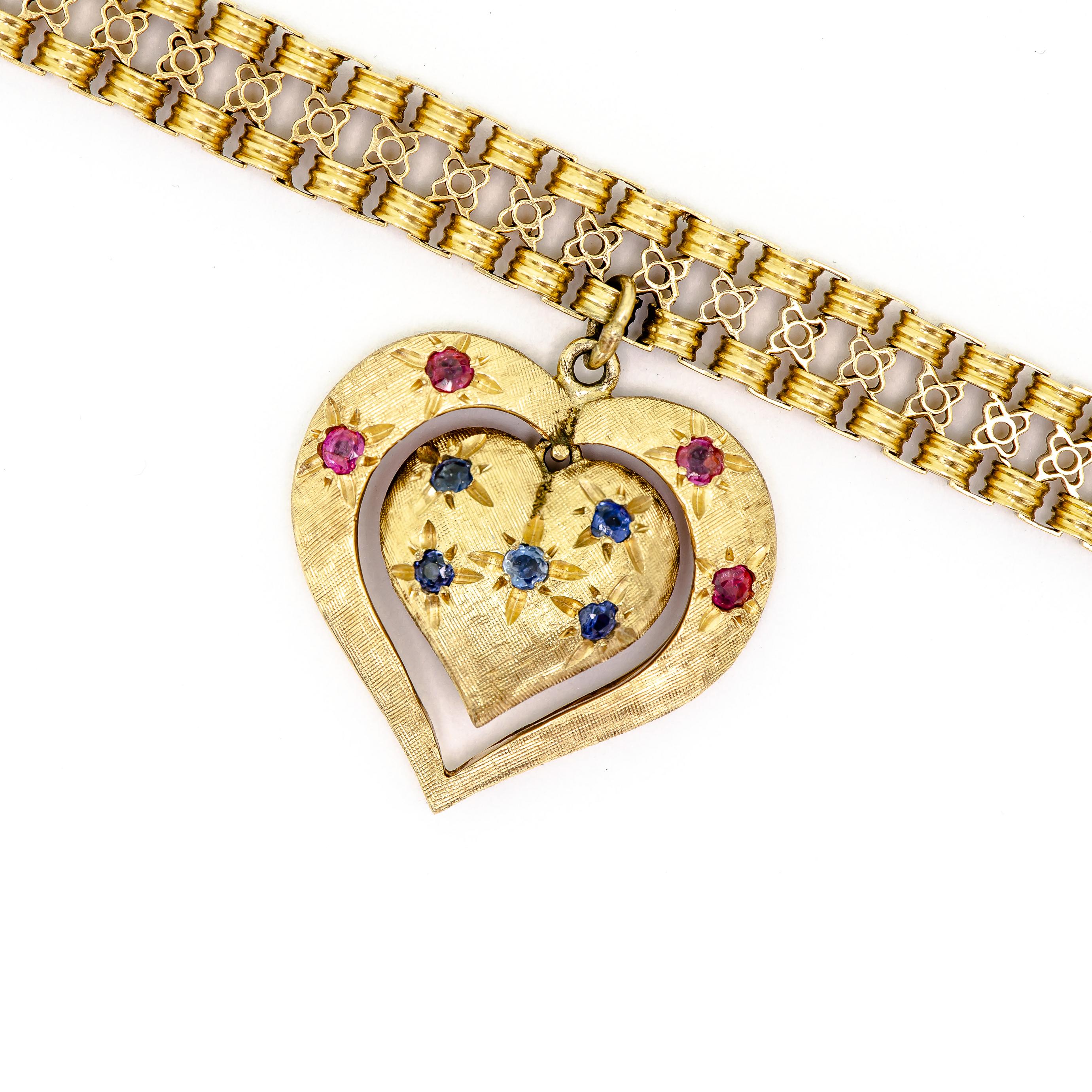 Vintage Mid Century 18KT yellow gold flexible bracelet fancy link with a brushed finish 14kt yellow gold articulated double sided heart charm with one side set with rubies and the other side set with blue sapphires. Gold safety