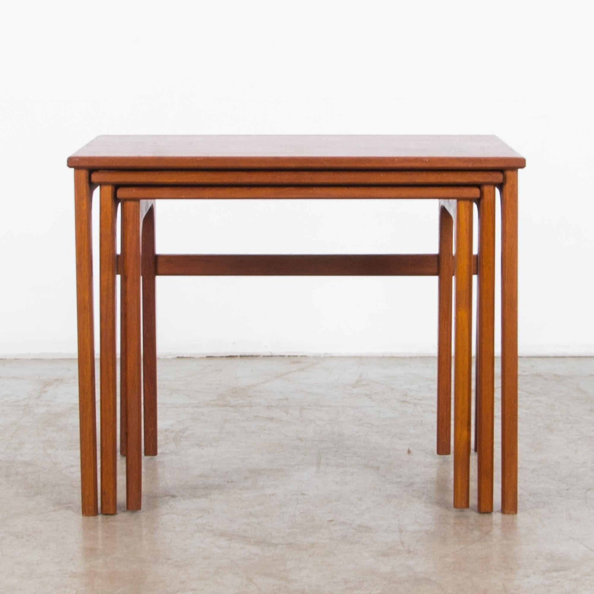 This set of wooden nesting tables was designed in Denmark in the 1970s. The pragmatic simplicity of the design is a stamp of Scandinavian Modernism; a simple rectangular tabletop sits atop smoothly tapered legs, which meet at two sides of the table