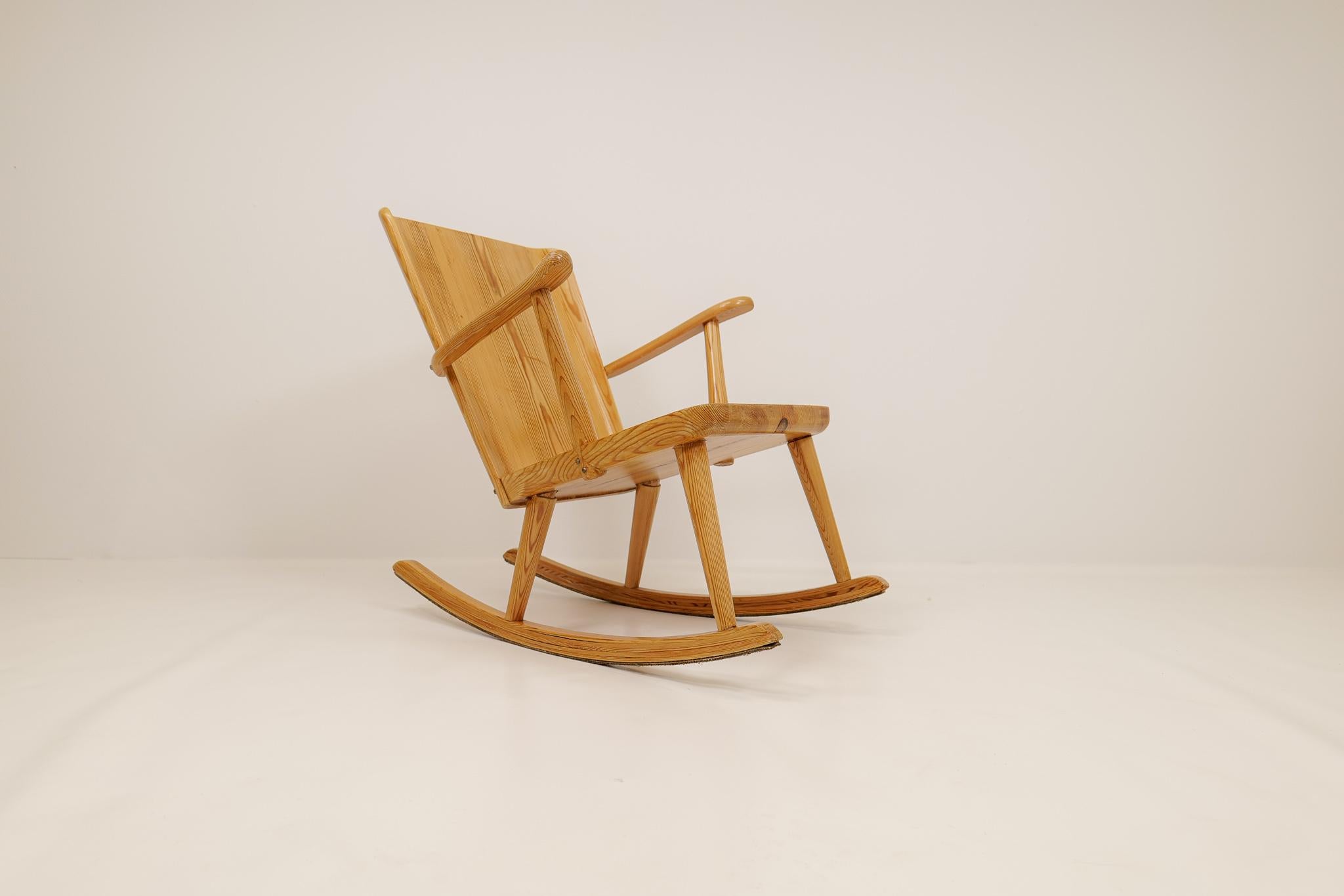 Rocking chair, made in solid pine, designed by Göran Malmvall for Svensk Fur, Sweden. 
Modernist design in traditional Swedish workmanship, made to adapt to the new era in the late 1930s and early 1940s Swedish summer houses. 

Overall patina on