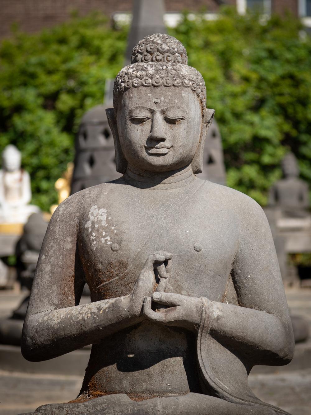 This large lavastone Buddha statue is a remarkable piece of art and spirituality. Crafted from lavastone, it stands at an impressive height of 136 cm, with dimensions of 121 cm in width and 84 cm in depth. Its estimated weight of approximately 800