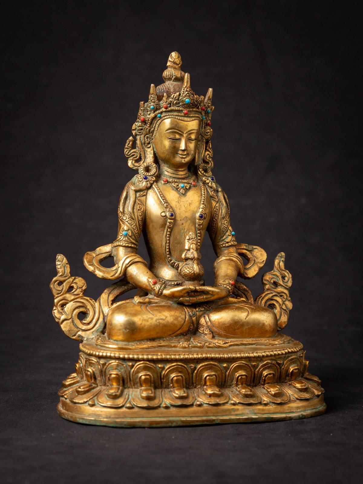 This Old bronze Nepali Aparmita Buddha statue is a remarkable piece of art that reflects the rich cultural and religious traditions of Nepal. Crafted from bronze and fire-gilded with 24-karat gold, this statue stands at a height of 22,9 cm, with