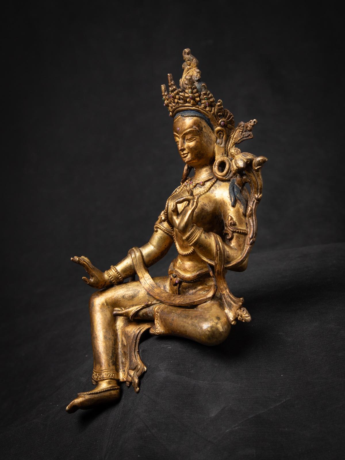 This Old bronze Nepali Green Tara statue. Crafted from bronze, it stands at a height of 26,4 cm, with dimensions of 15,8 cm in width and 11,5 cm in depth, making it a beautifully detailed and spiritually significant work of art.Fire gilded with 24