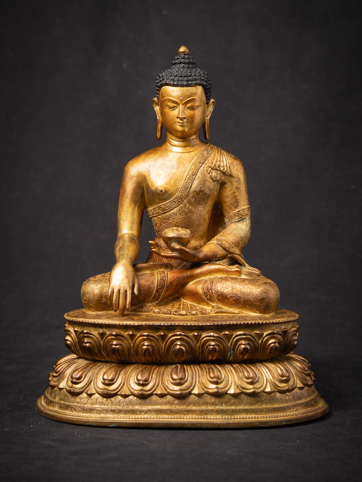This old bronze Nepali Buddha statue is a striking and high-quality example of mid-20th century Himalayan artistry, originating from the culturally rich region of Nepal. Expertly cast in bronze and fire gilded with 24 karat gold, the statue radiates